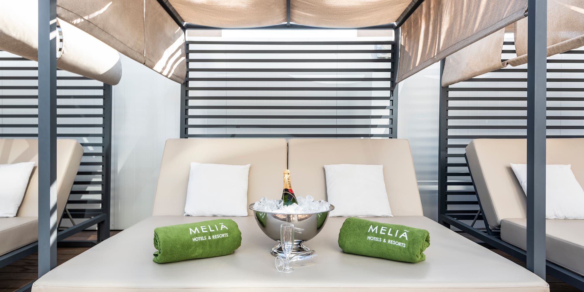 a lounge chair with a champagne bottle and towels on it