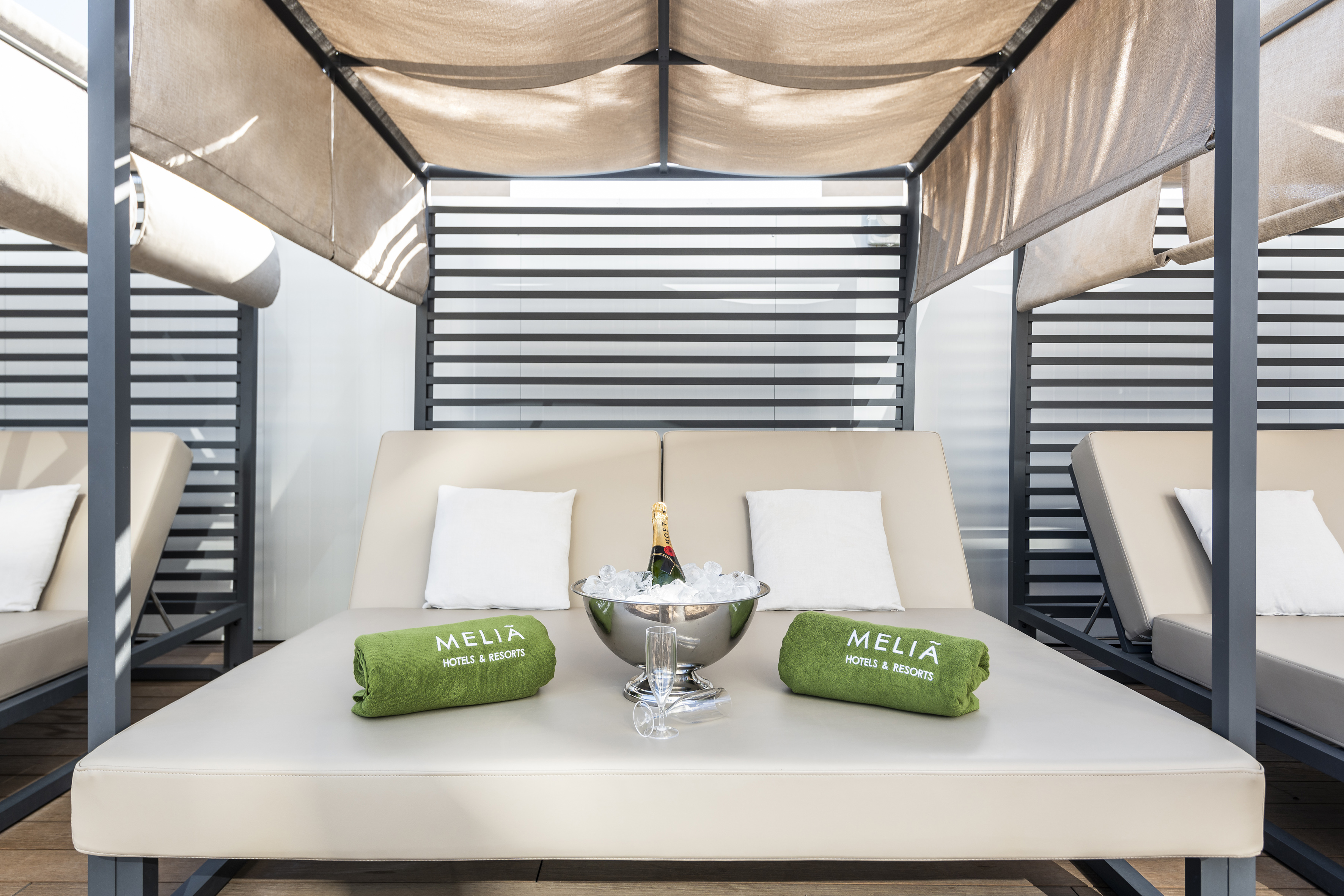 a lounge chair with a champagne bottle and towels on it