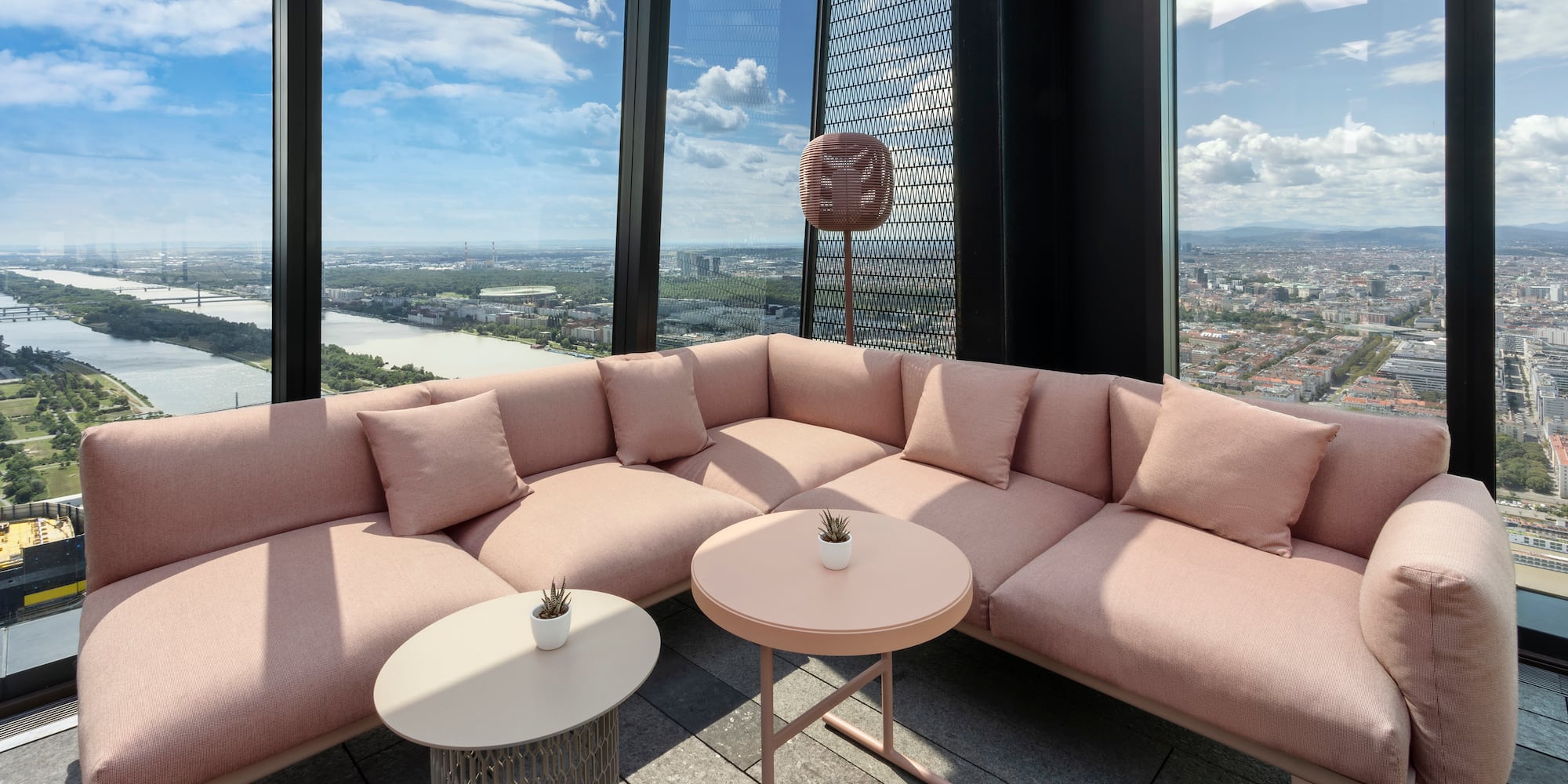 a large couch with a table and chairs in a room with large windows