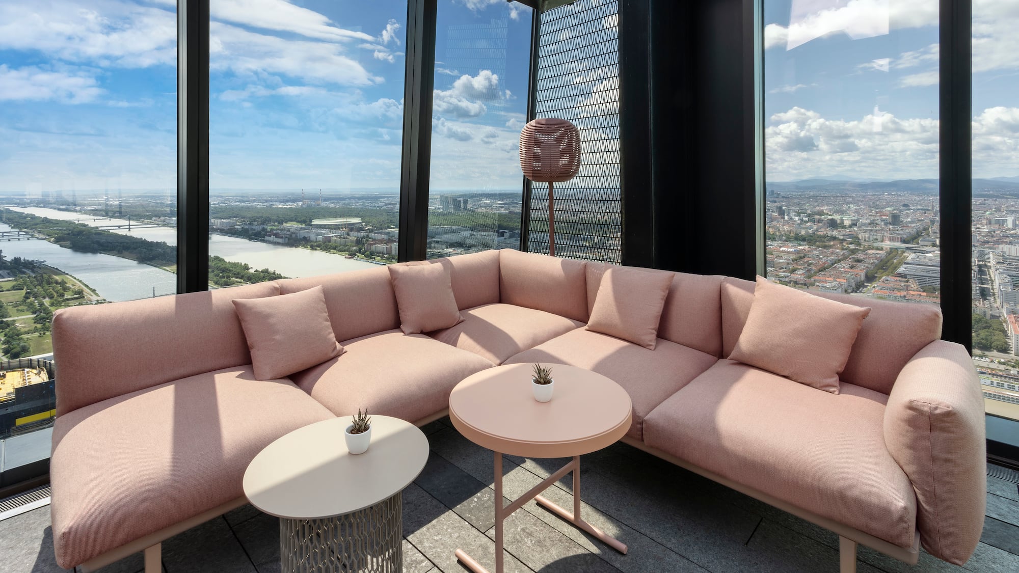 a large couch with a table and chairs in a room with large windows