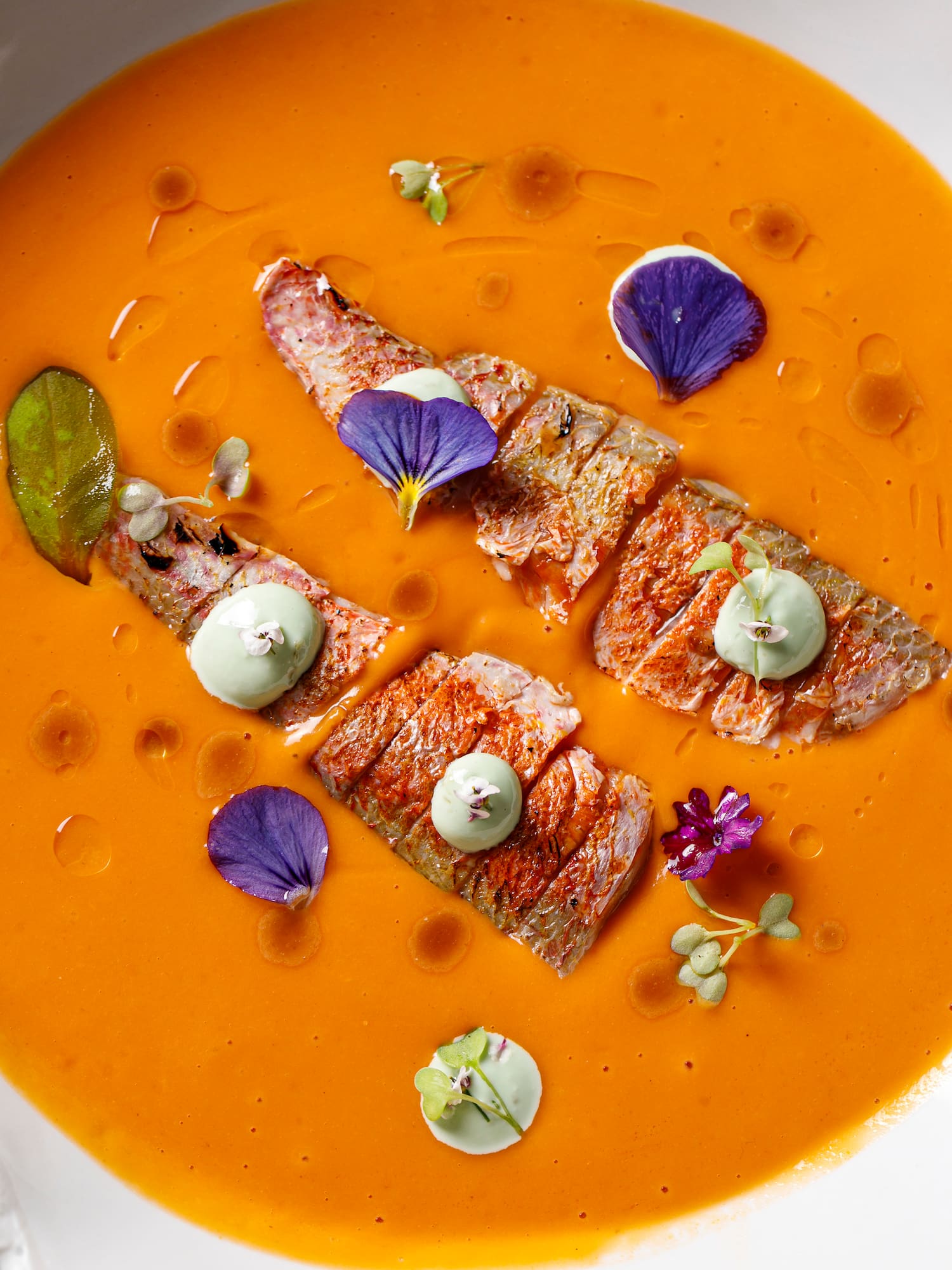 a bowl of soup with meat and flowers