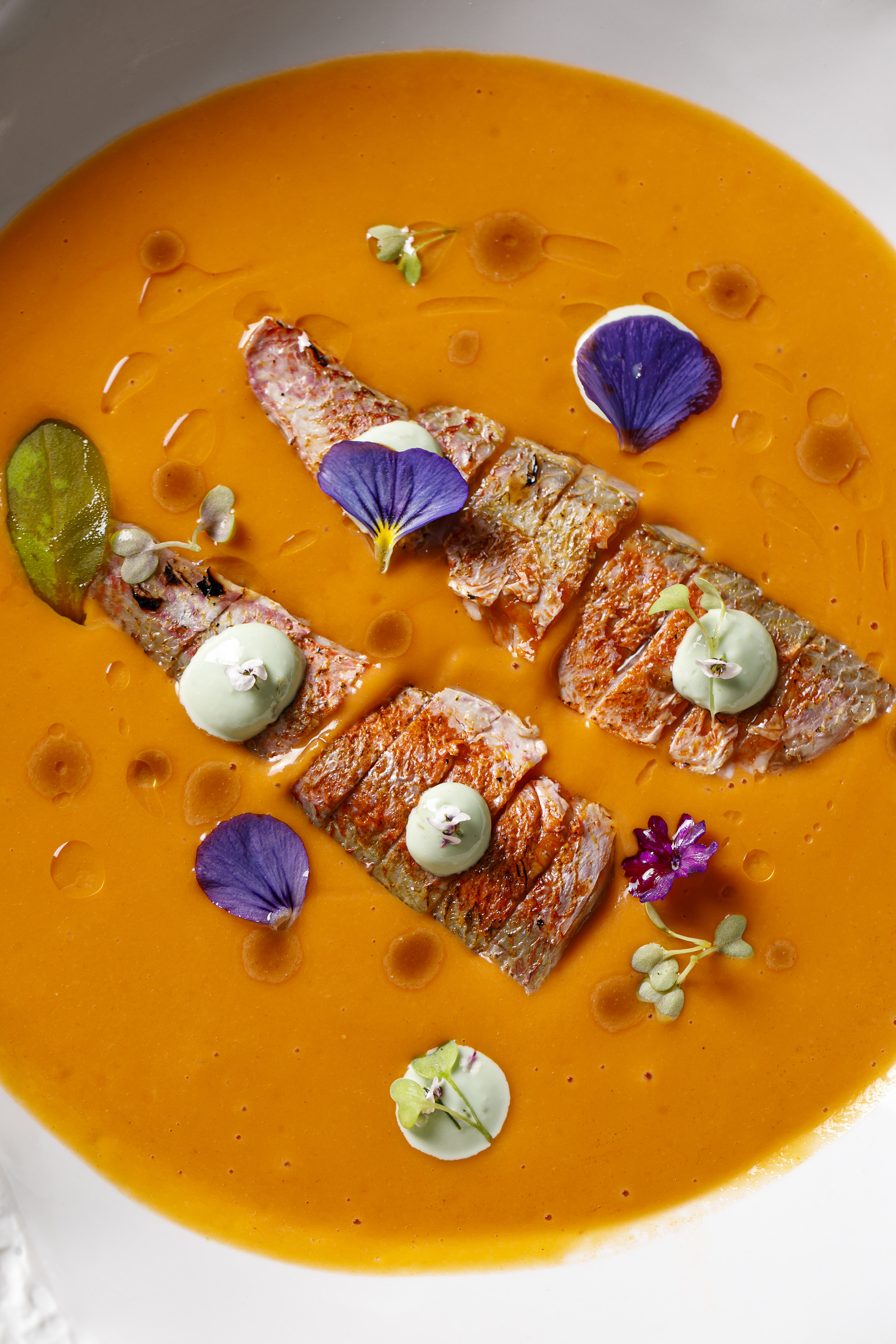 a bowl of soup with meat and flowers