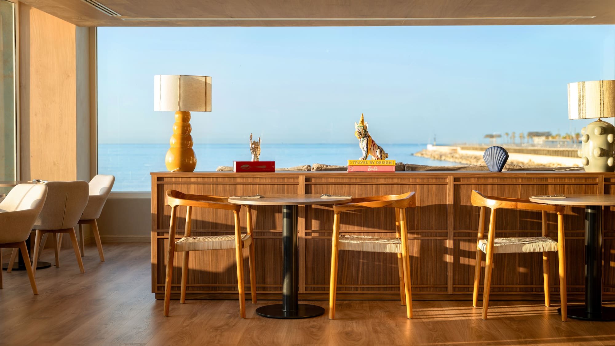 a room with a table and chairs and a large window