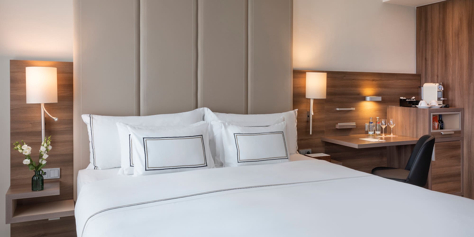 a bed with white sheets and a desk