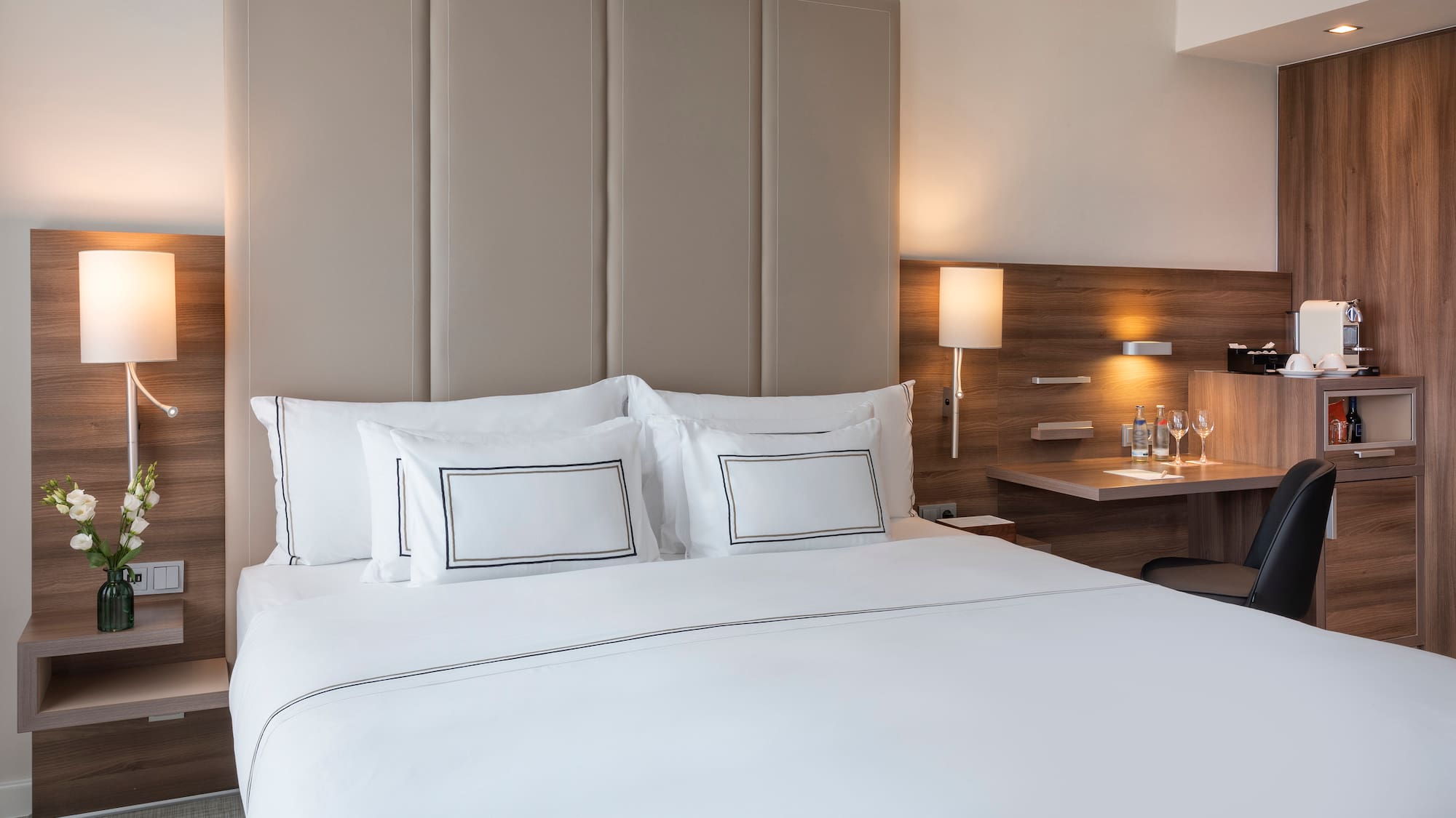 a bed with white sheets and a desk