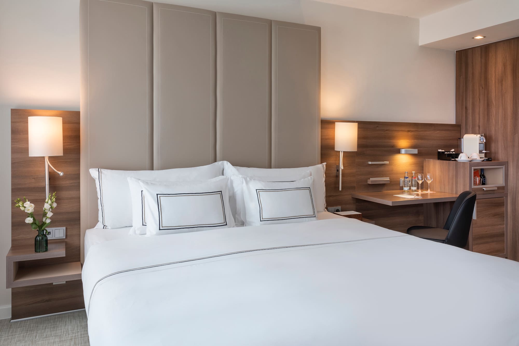 a bed with white sheets and a desk