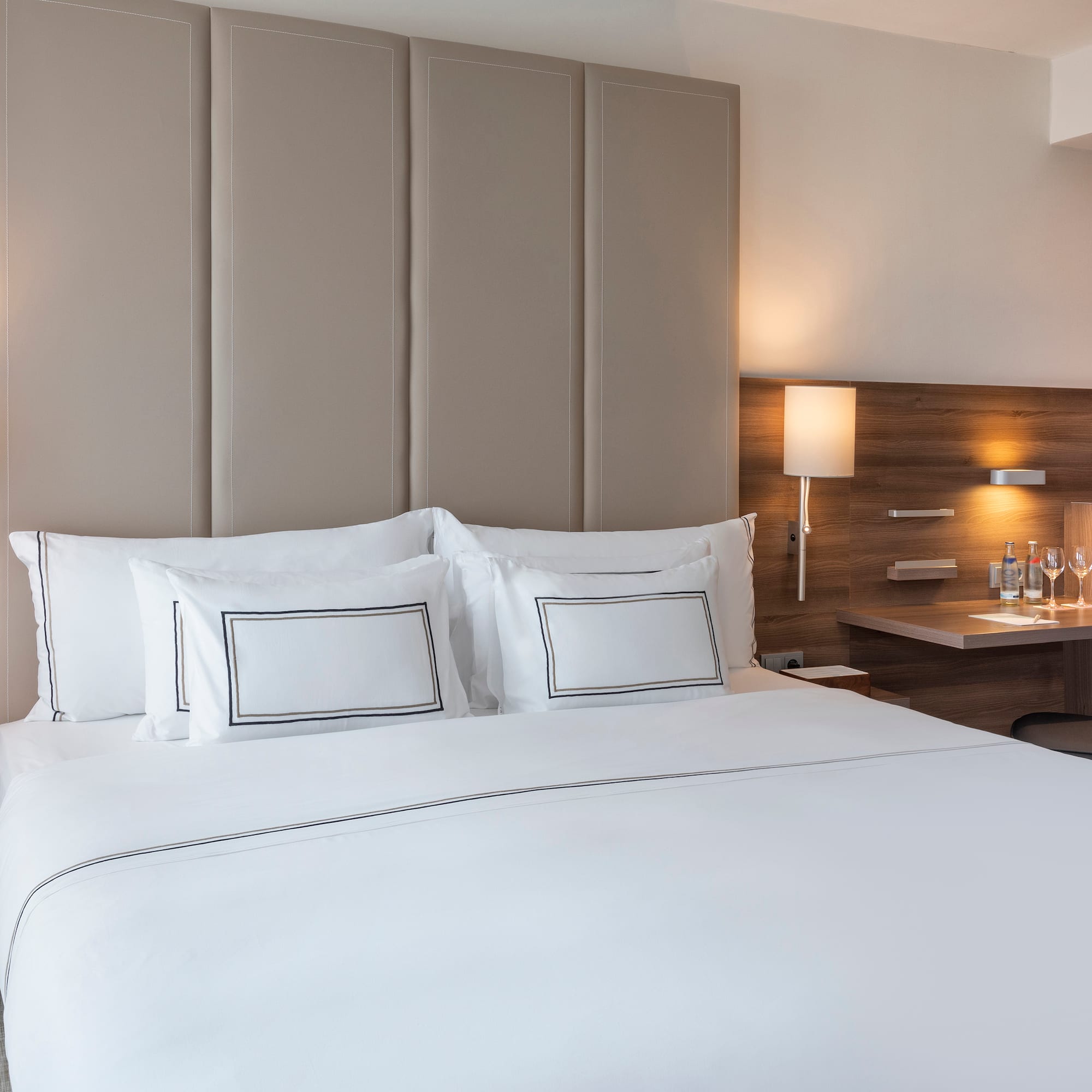 a bed with white sheets and a desk