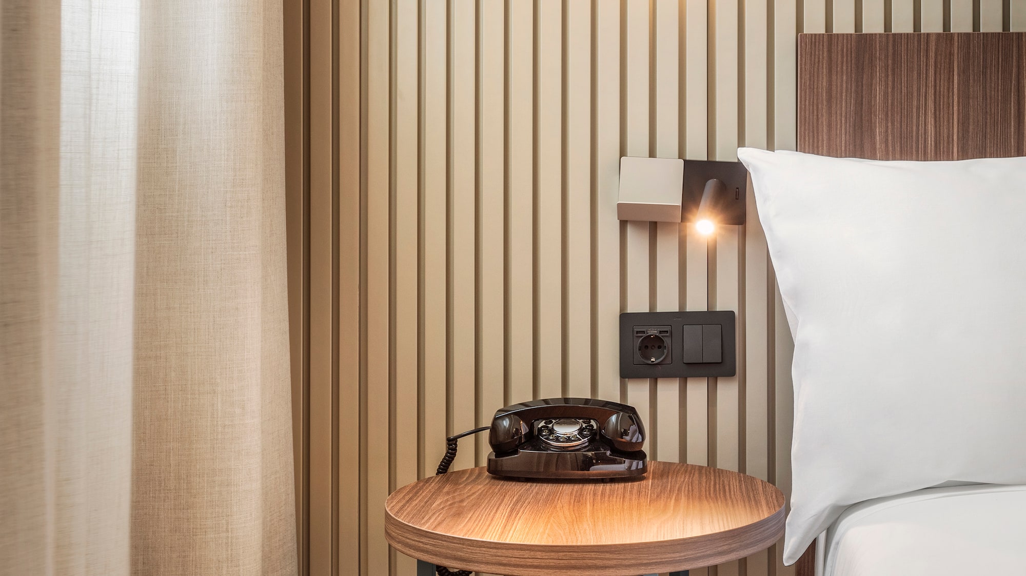 a bed with a telephone on a table