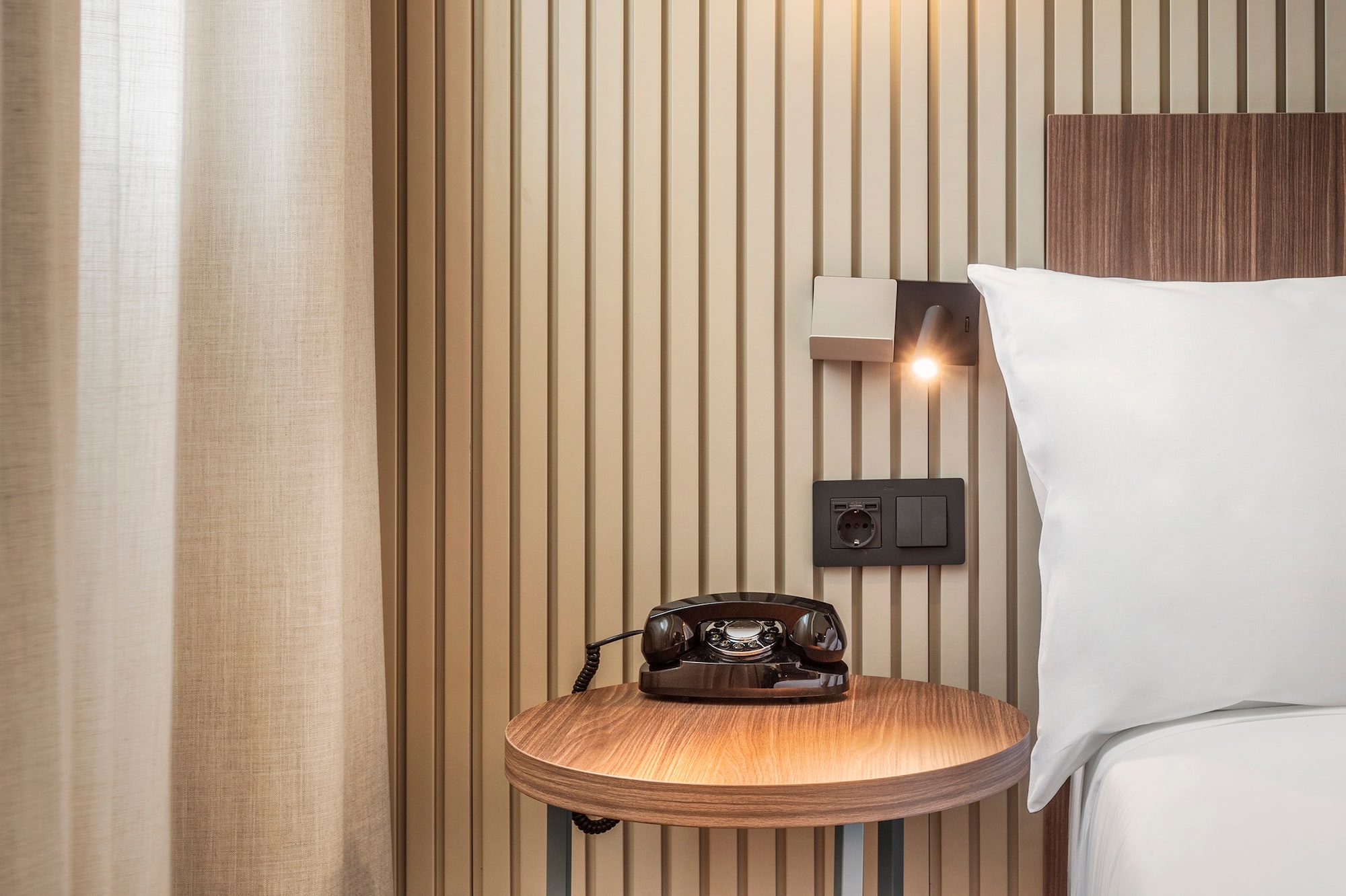 a bed with a telephone on a table