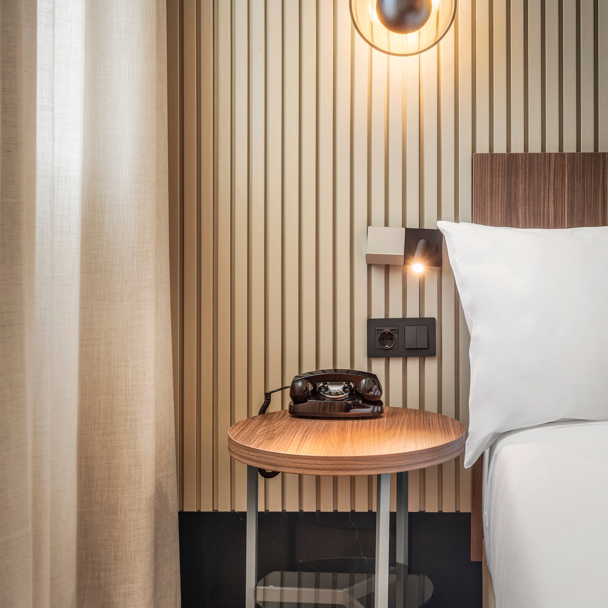 a bed with a telephone on a table