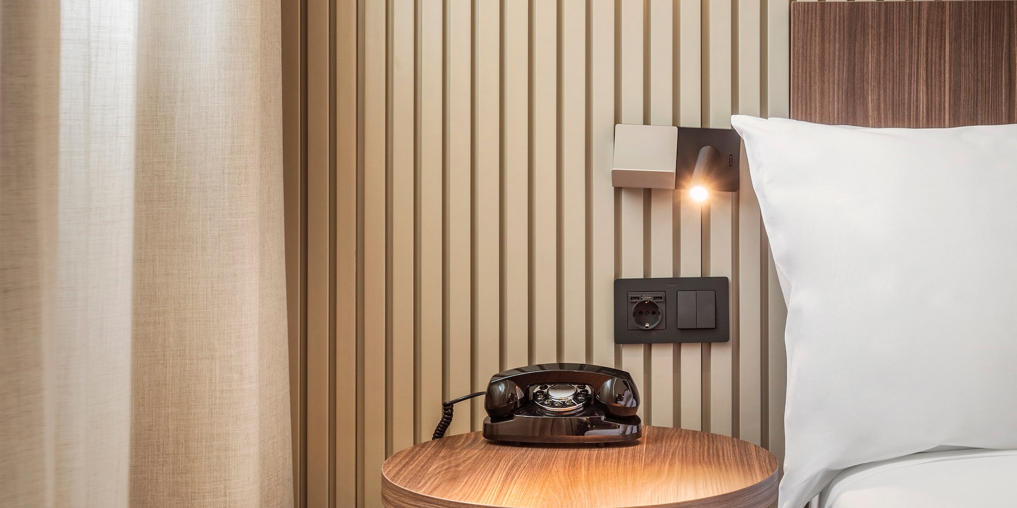 a bed with a telephone on a table