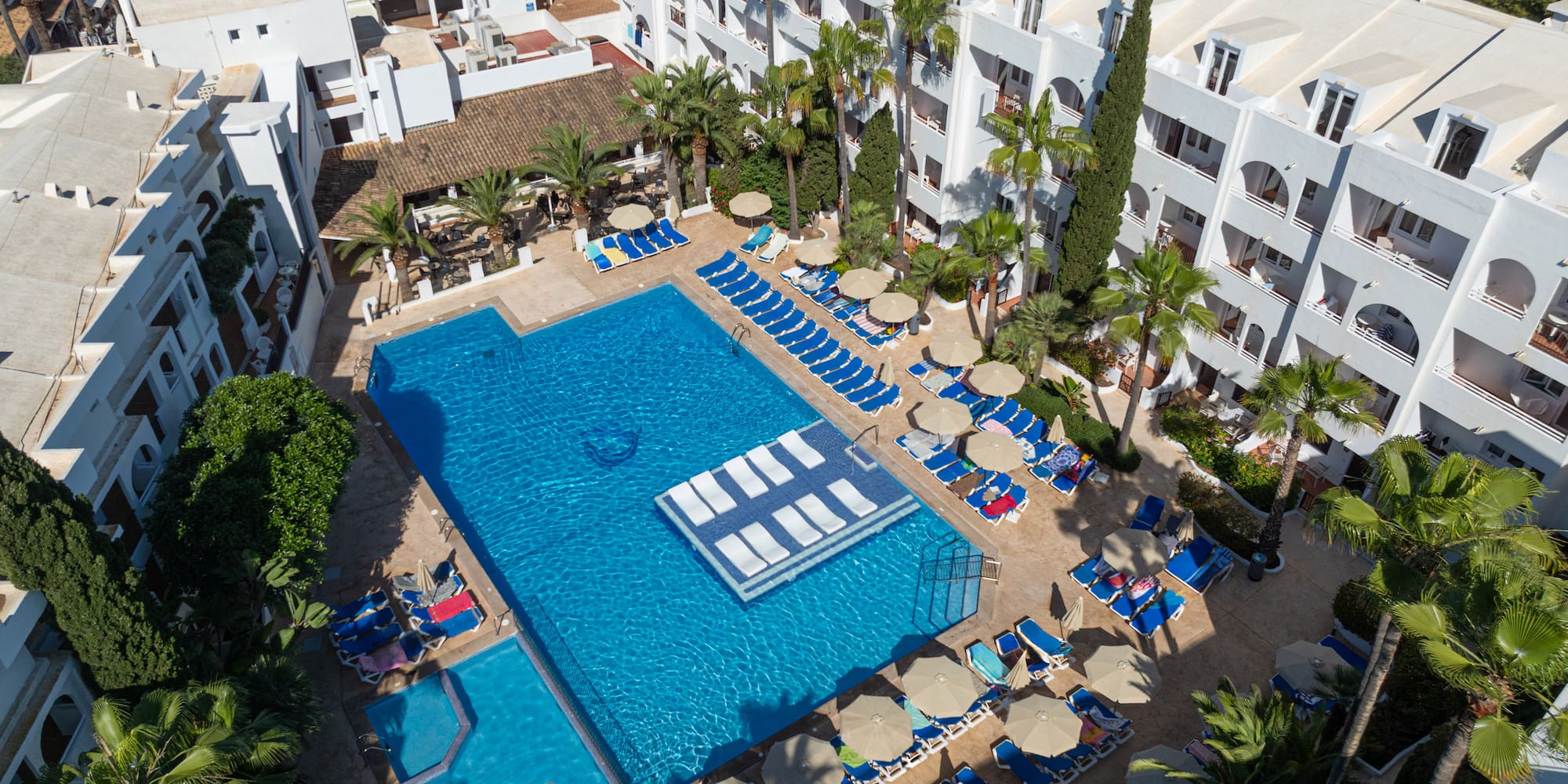 a swimming pool with lounge chairs and umbrellas in a resort