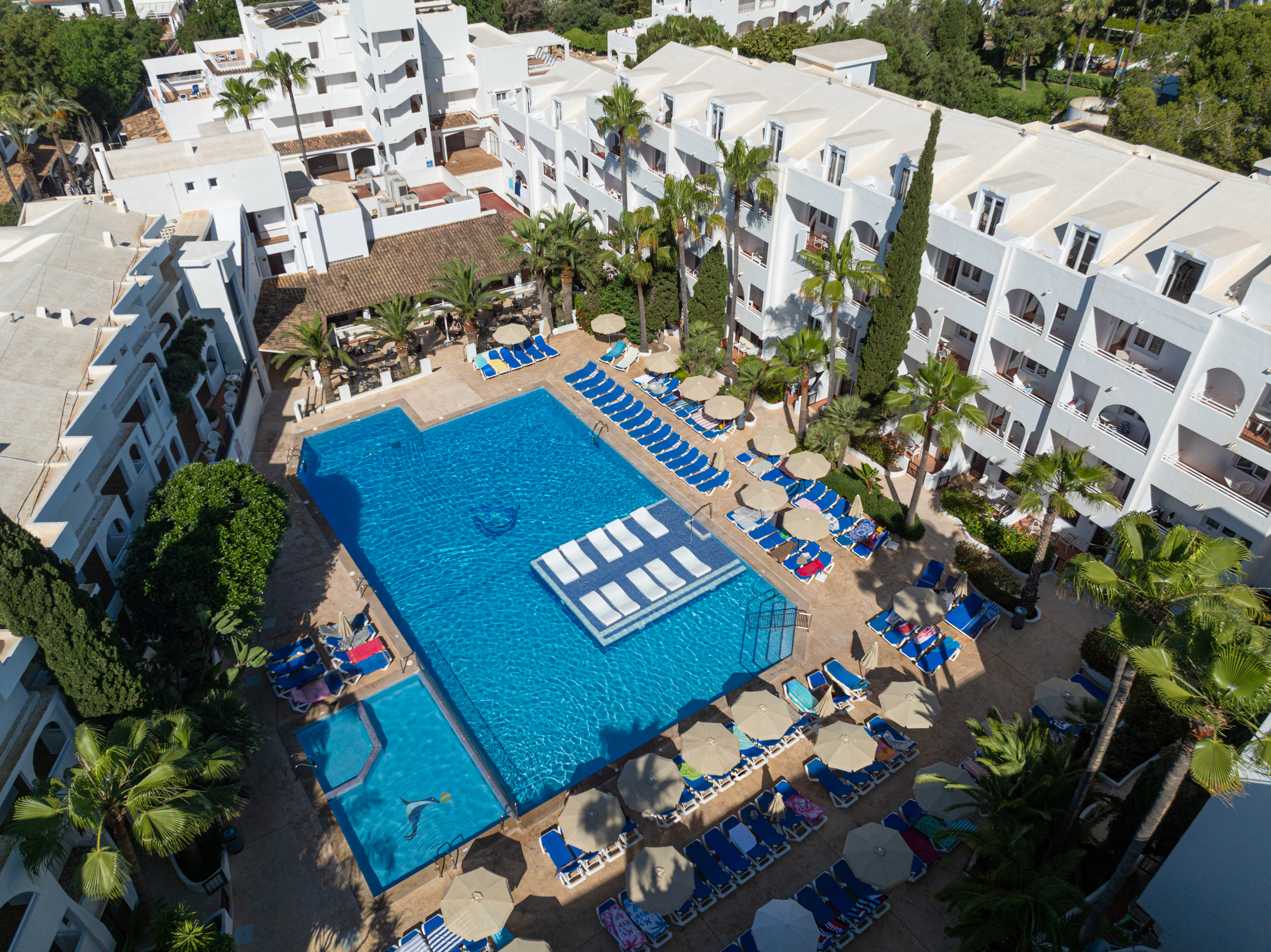 a swimming pool with lounge chairs and umbrellas in a resort