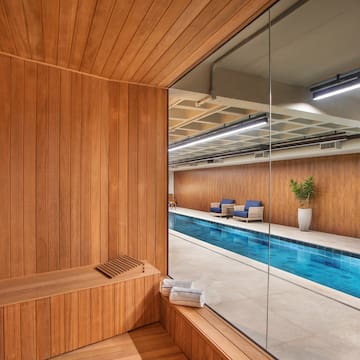 a room with a pool and a wooden bench