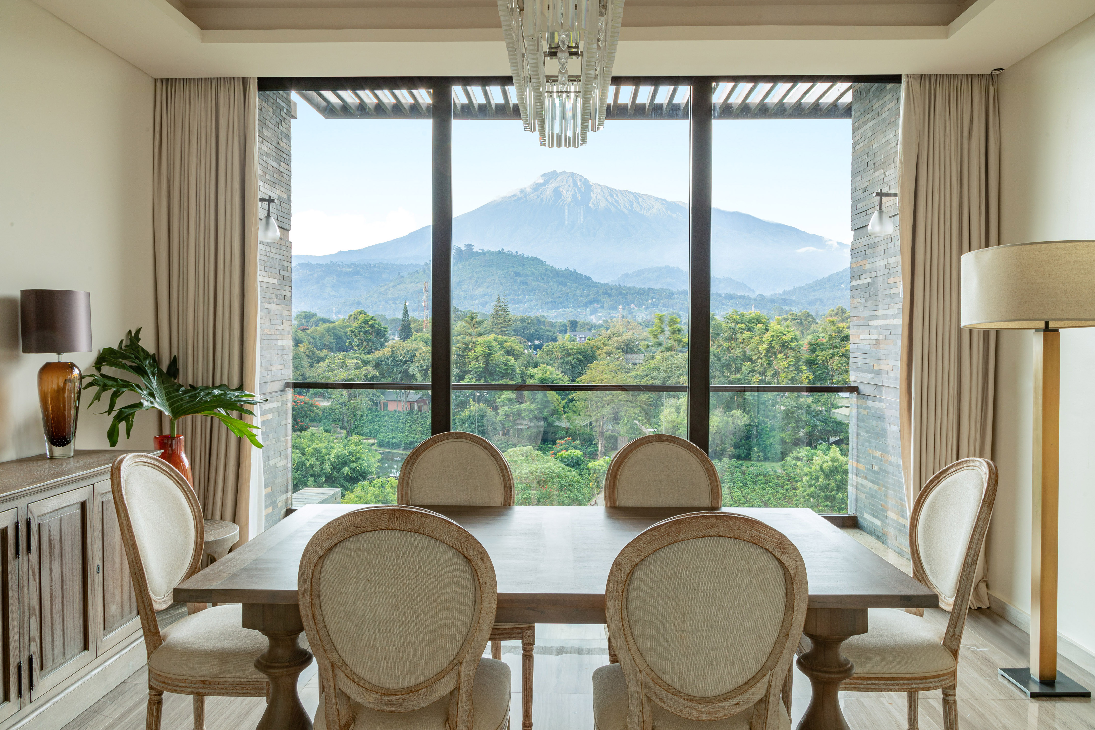 a dining room with a table and chairs and a mountain in the background