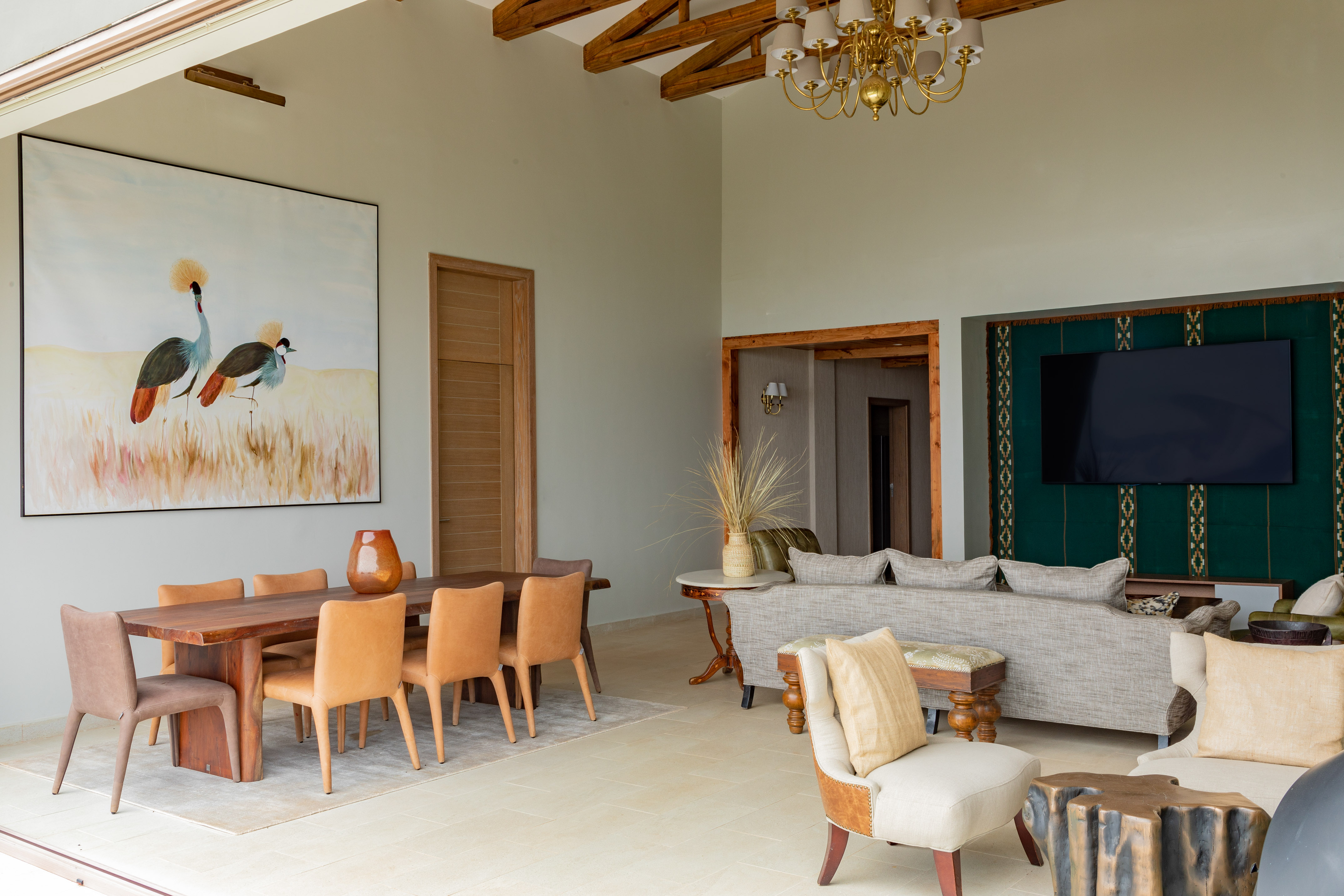 Modern living and dining room with crane art, sofa, and wood table.
