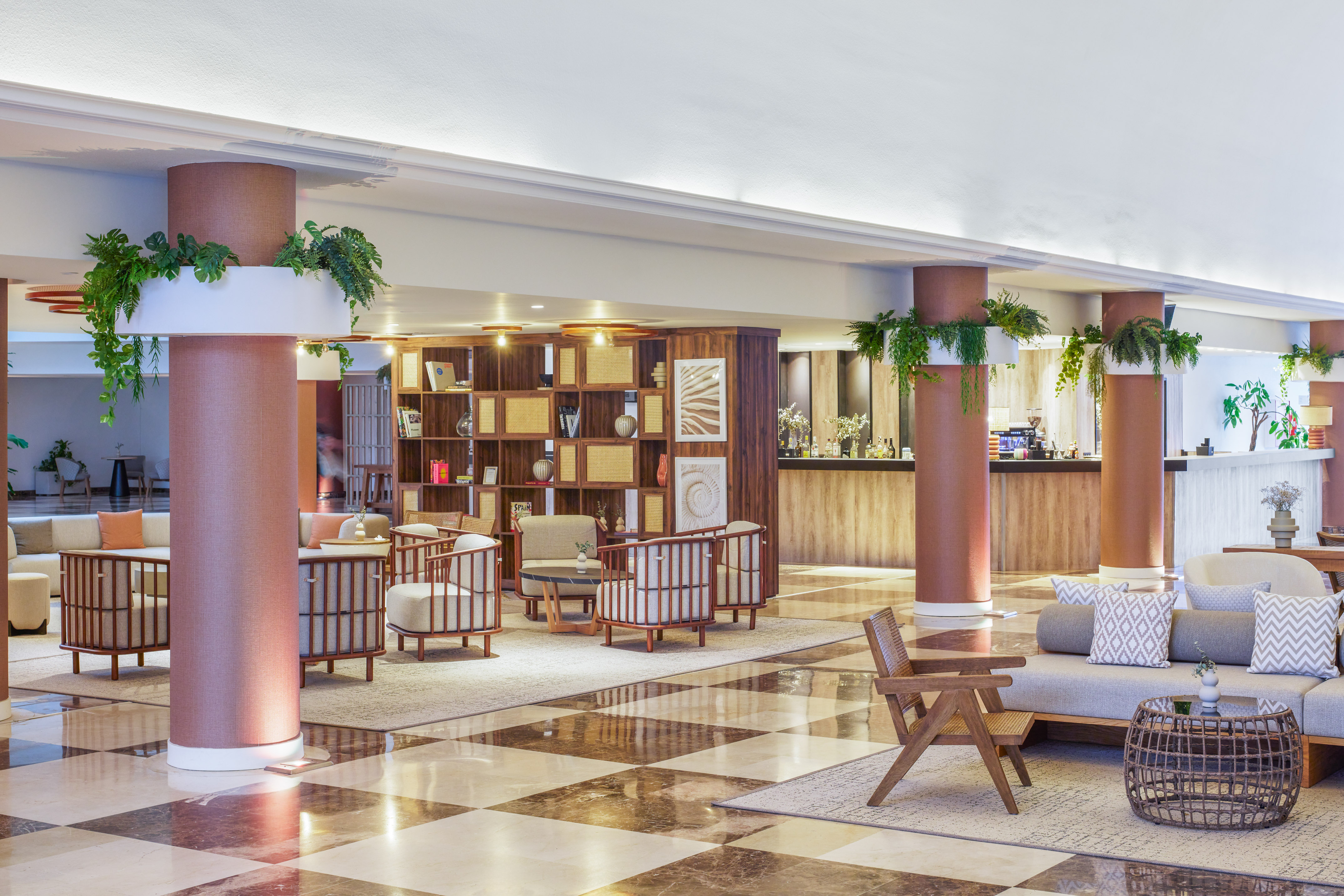 Modern hotel lobby lounge with green plants, stylish seating, and marble floor.