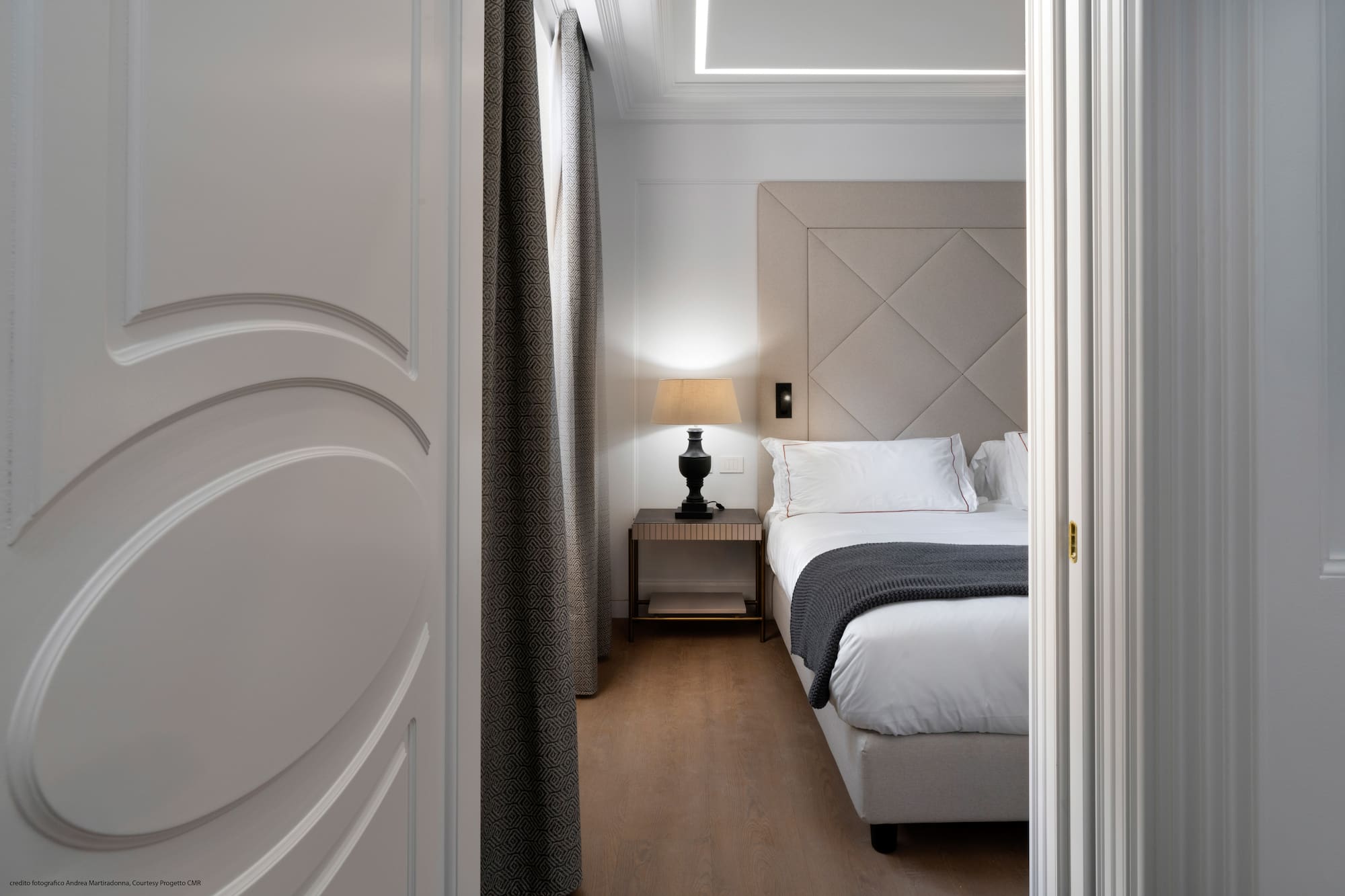 a bedroom with a bed and a lamp