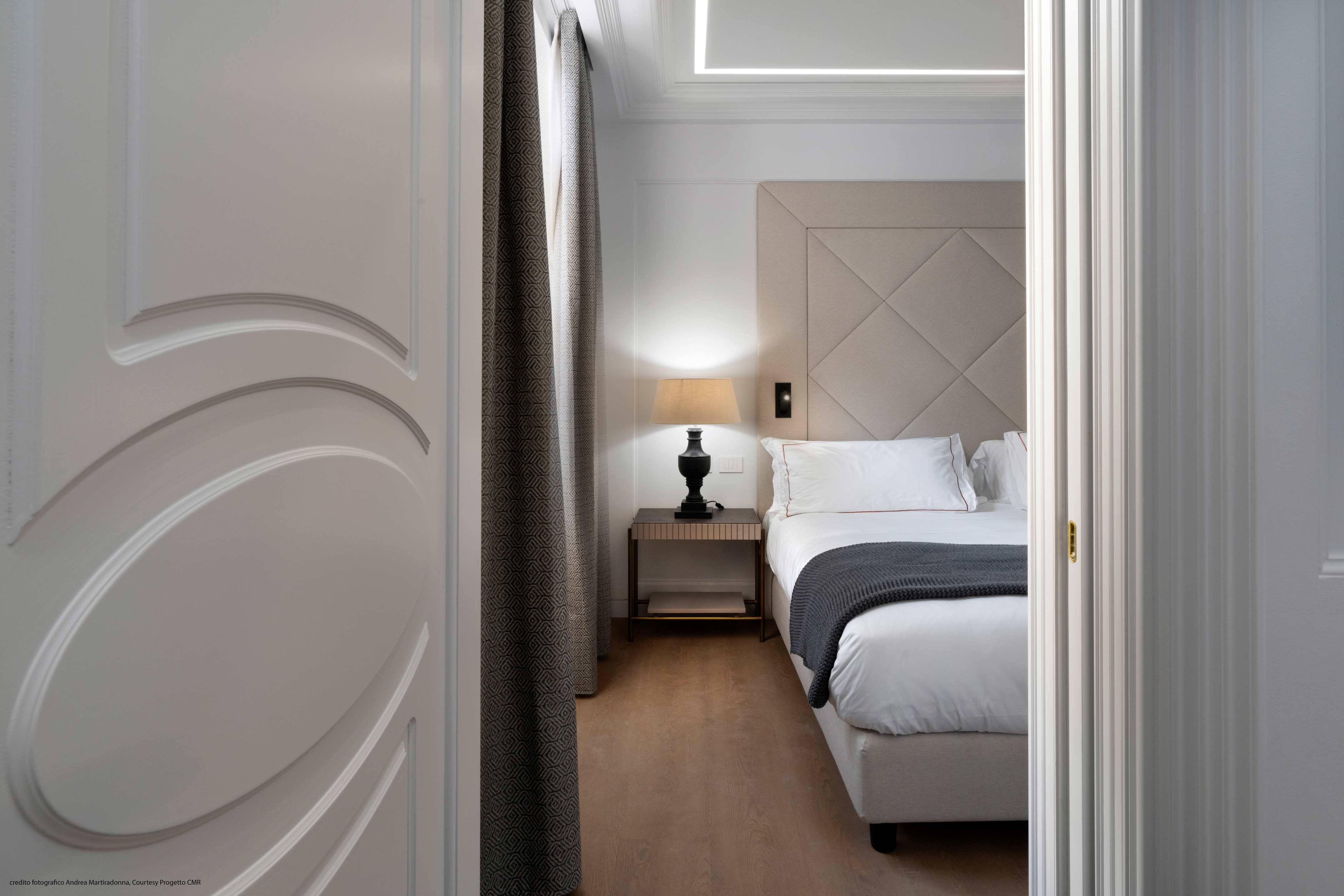 a bedroom with a bed and a lamp