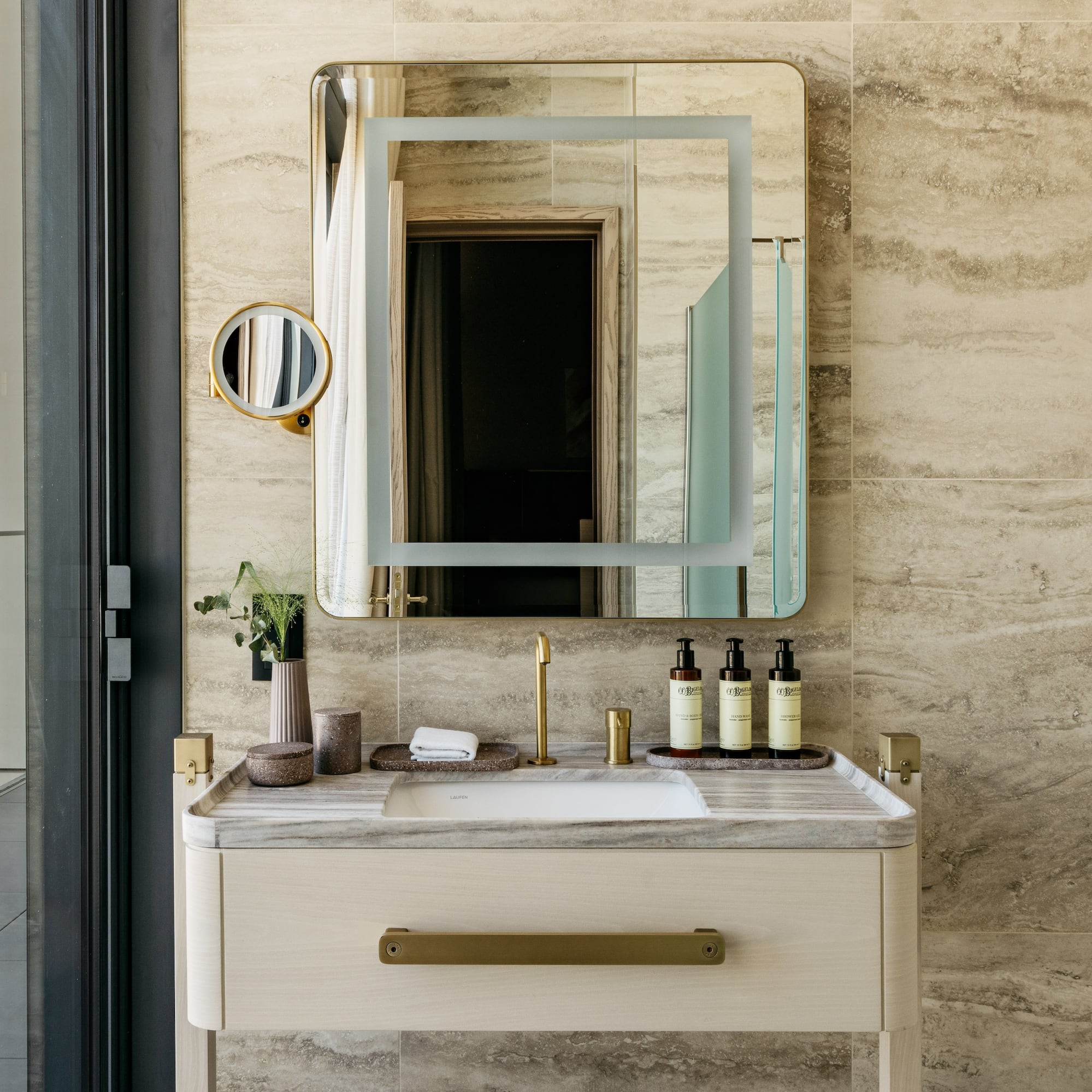 a bathroom sink with a mirror and a plant