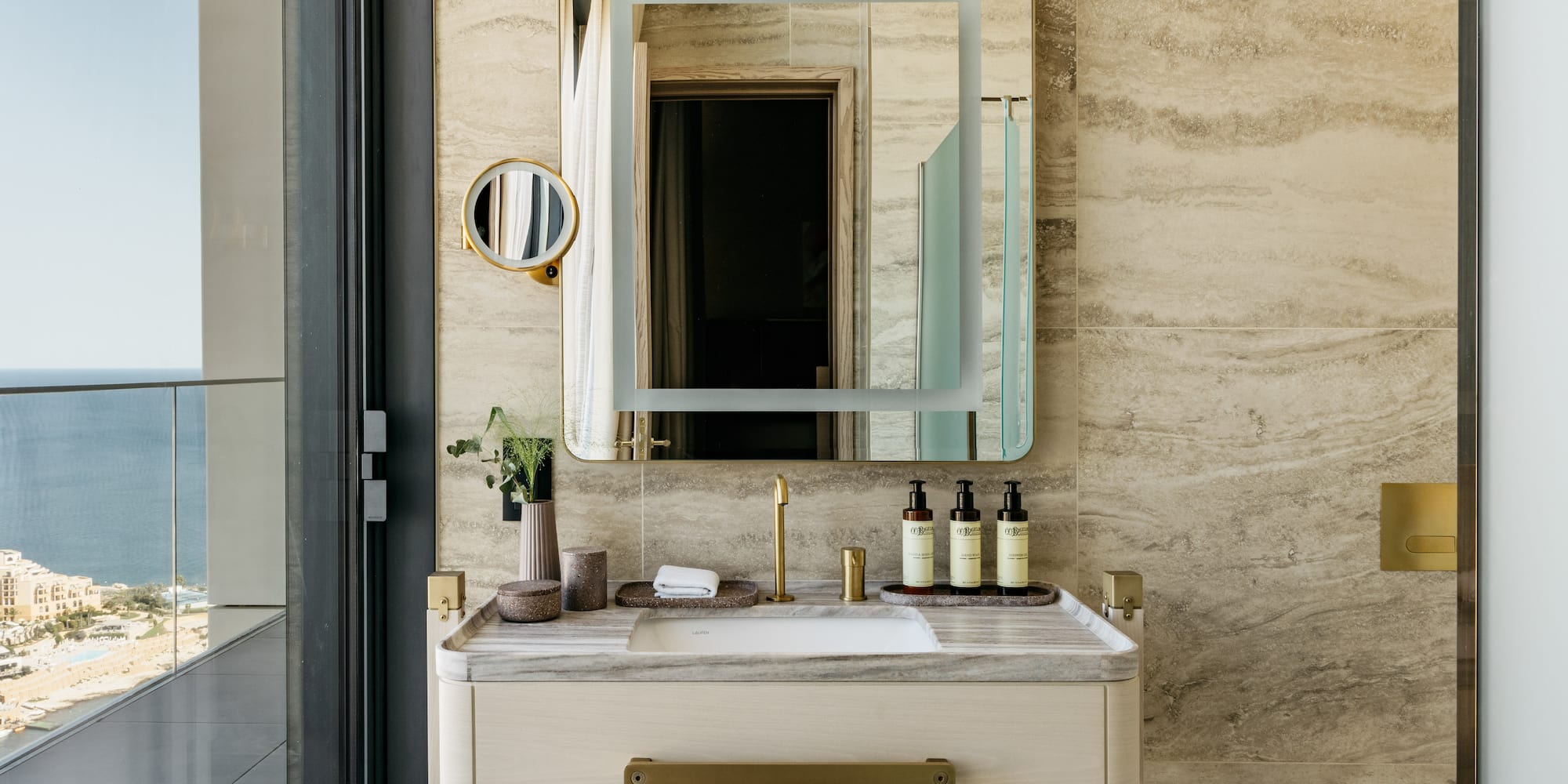 a bathroom sink with a mirror and a plant