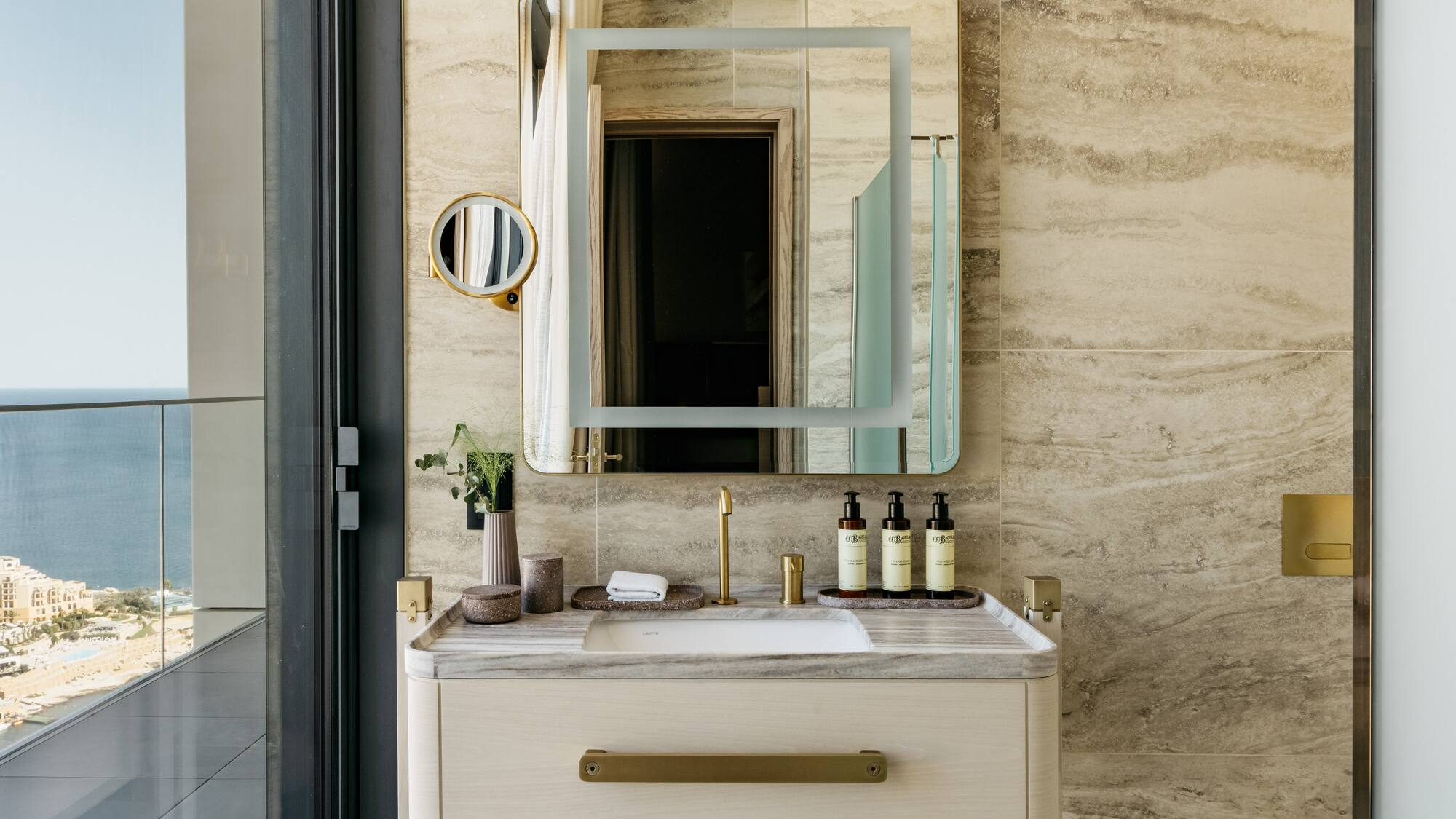 a bathroom sink with a mirror and a plant