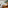 Modern hotel room, large bed, green accent wall, freestanding tub, balcony.