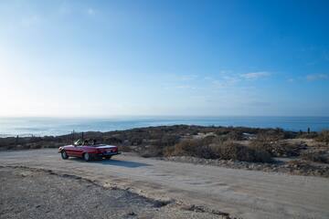 a car parked on a dirt road near water