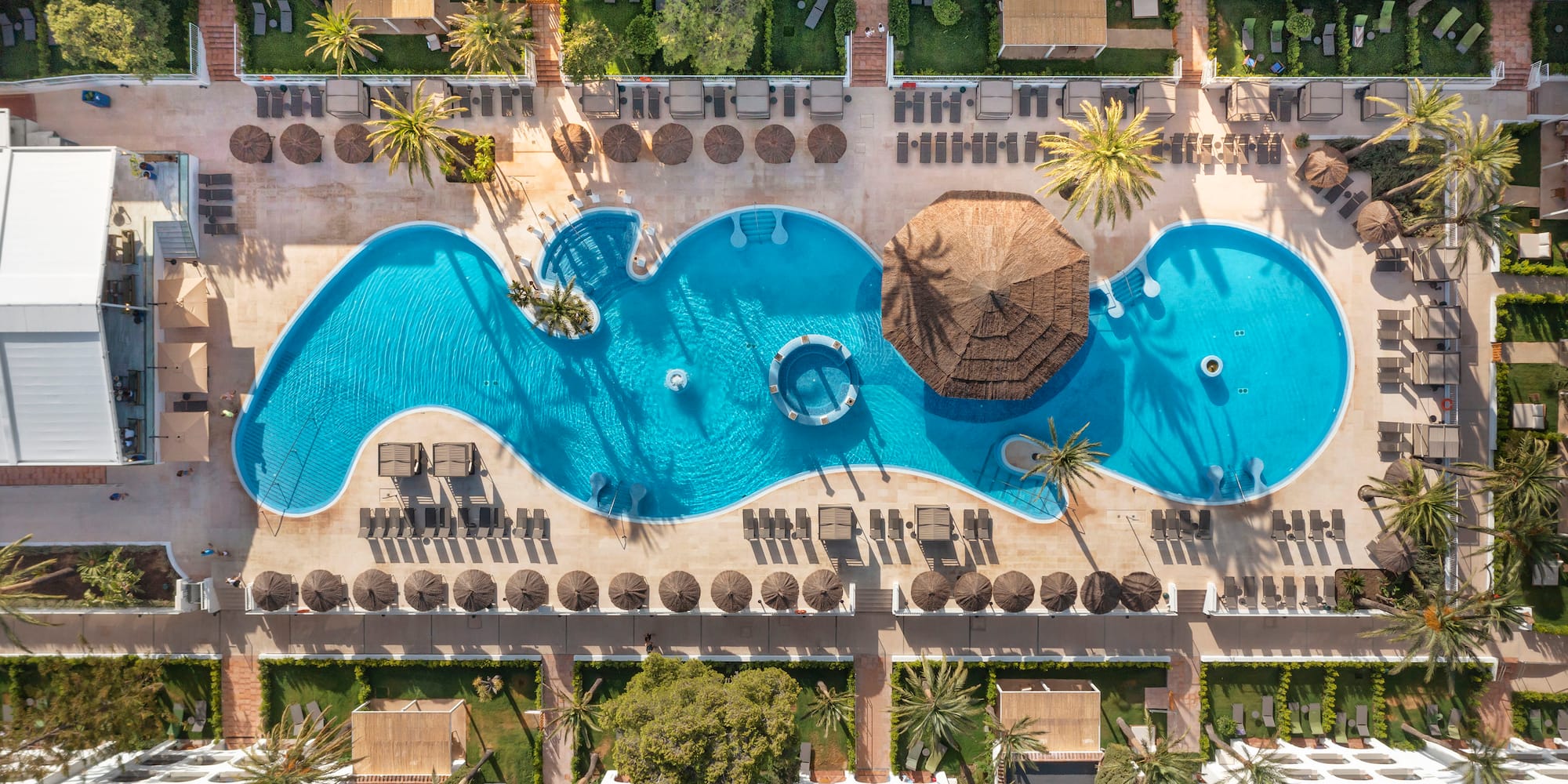 a pool with a hut and a umbrella