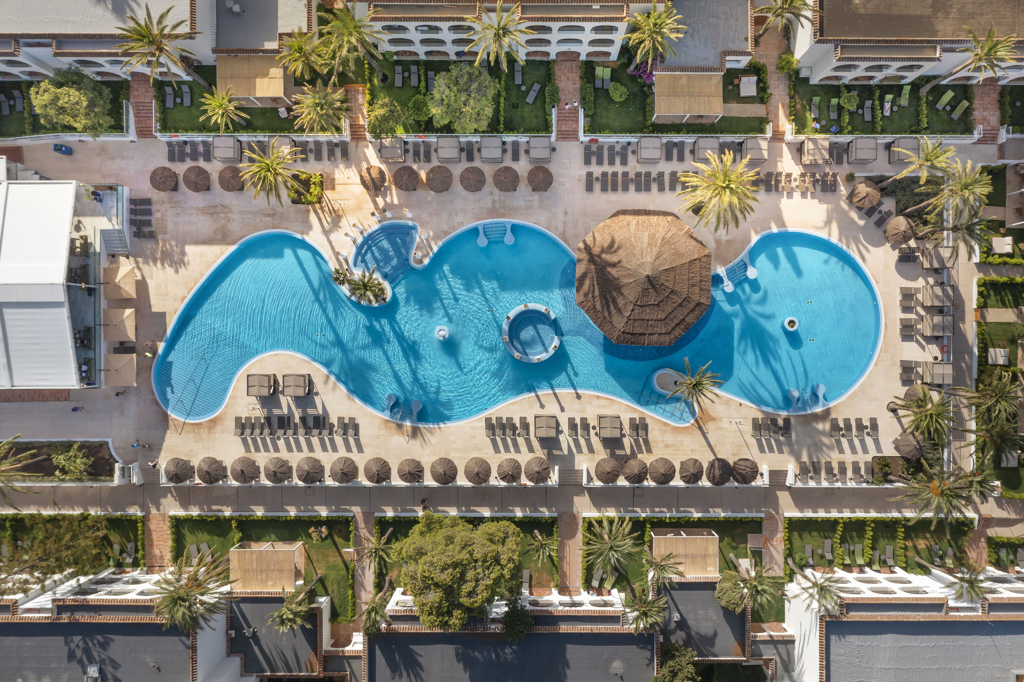 a pool with a hut and a umbrella