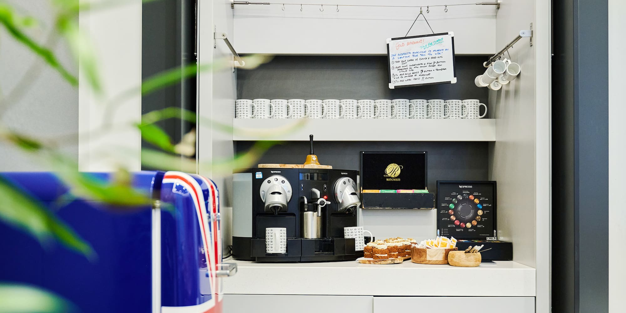 a coffee machine and cupcakes on a counter