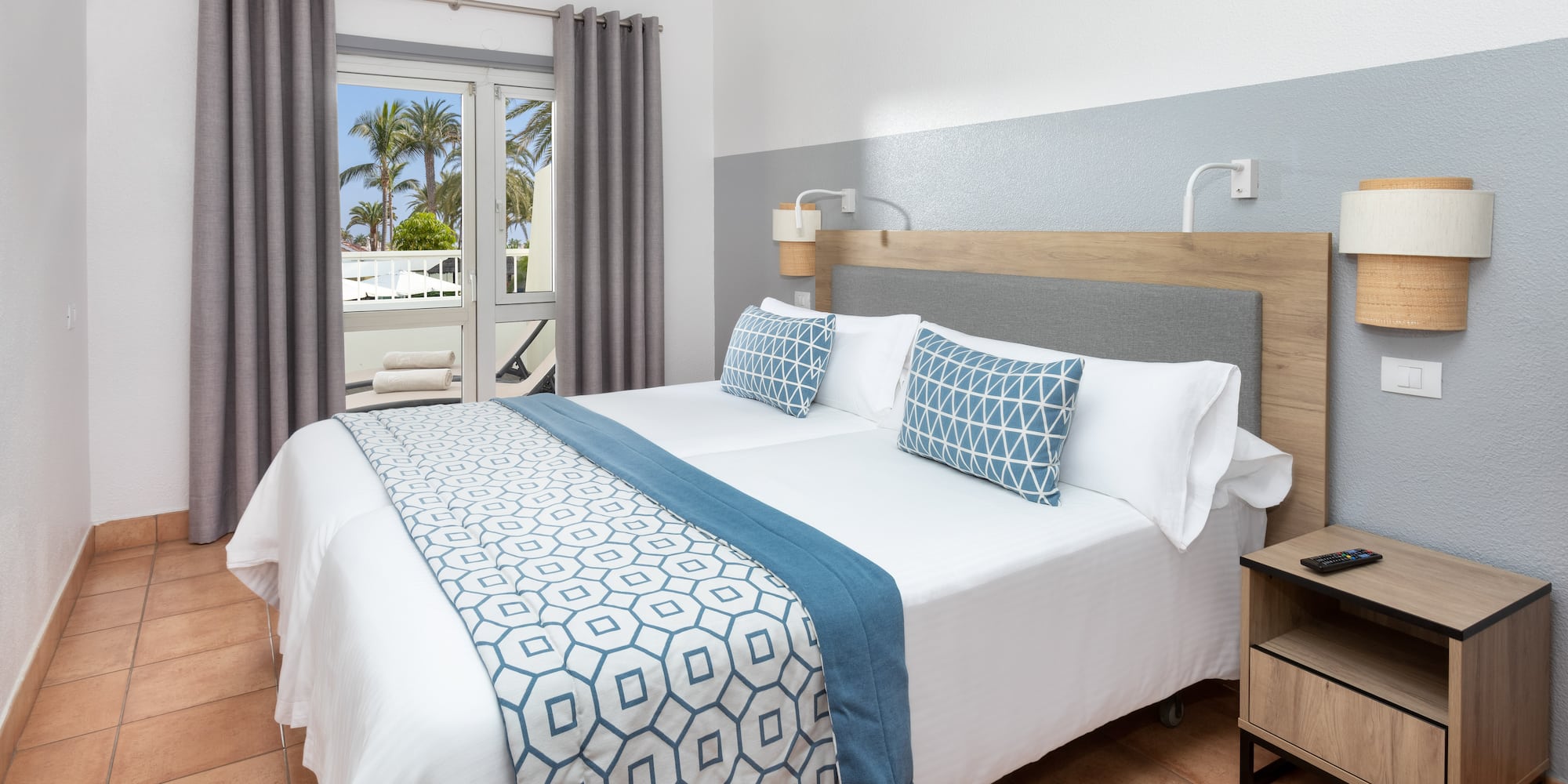 a bed with a wood headboard and blue and white pillows