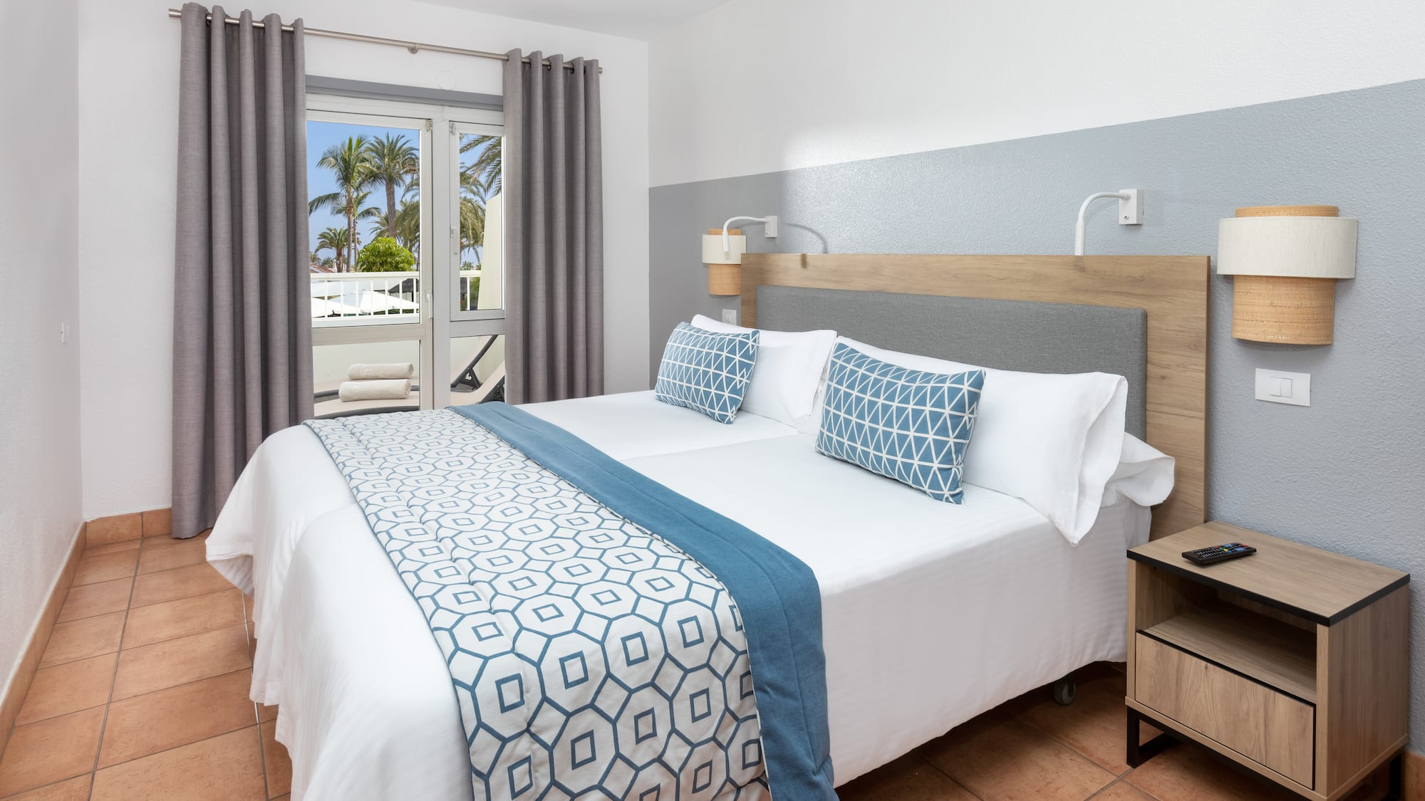 a bed with a wood headboard and blue and white pillows