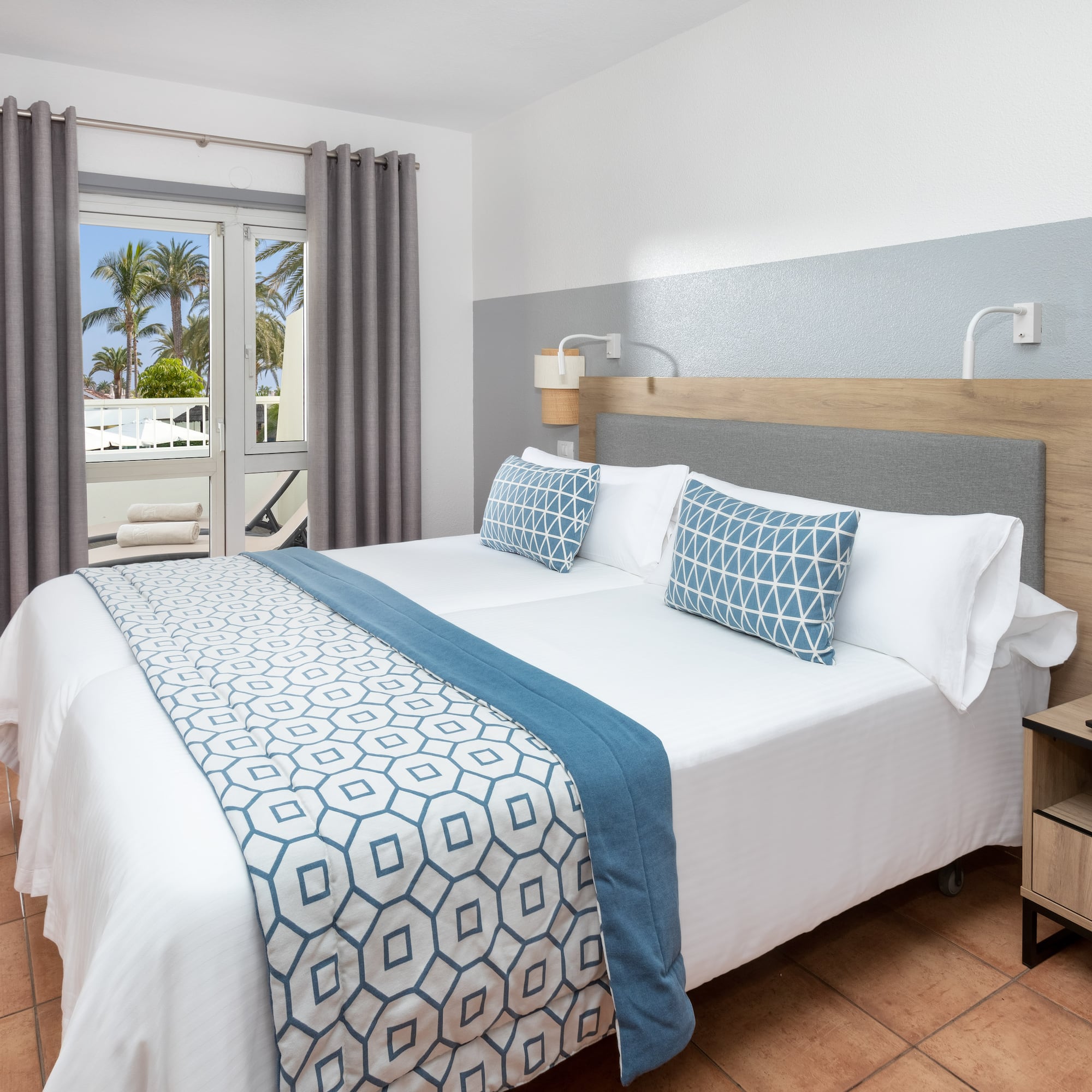 a bed with a wood headboard and blue and white pillows