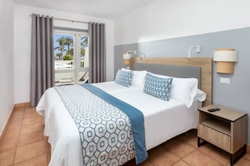 a bed with a wood headboard and blue and white pillows