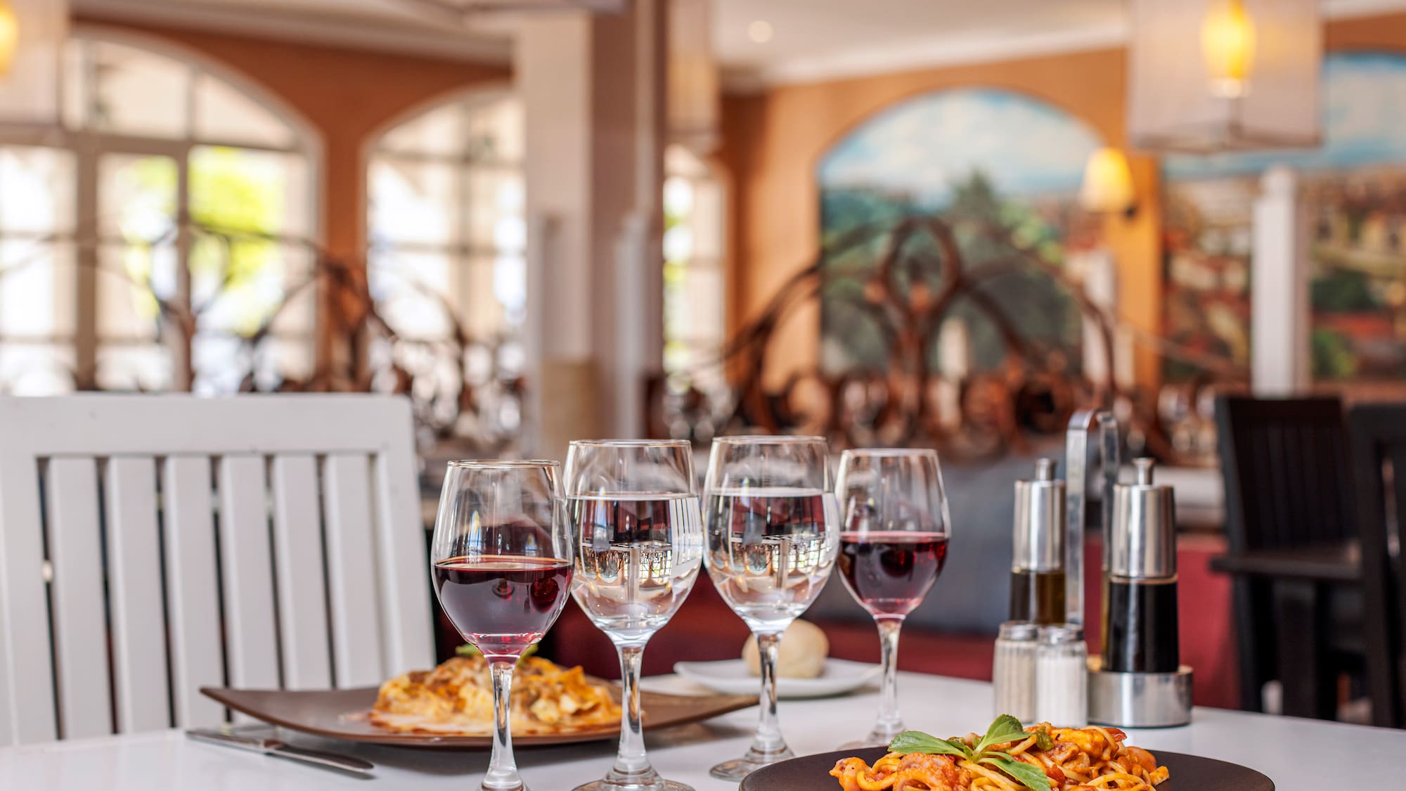 a table with plates of food and wine glasses
