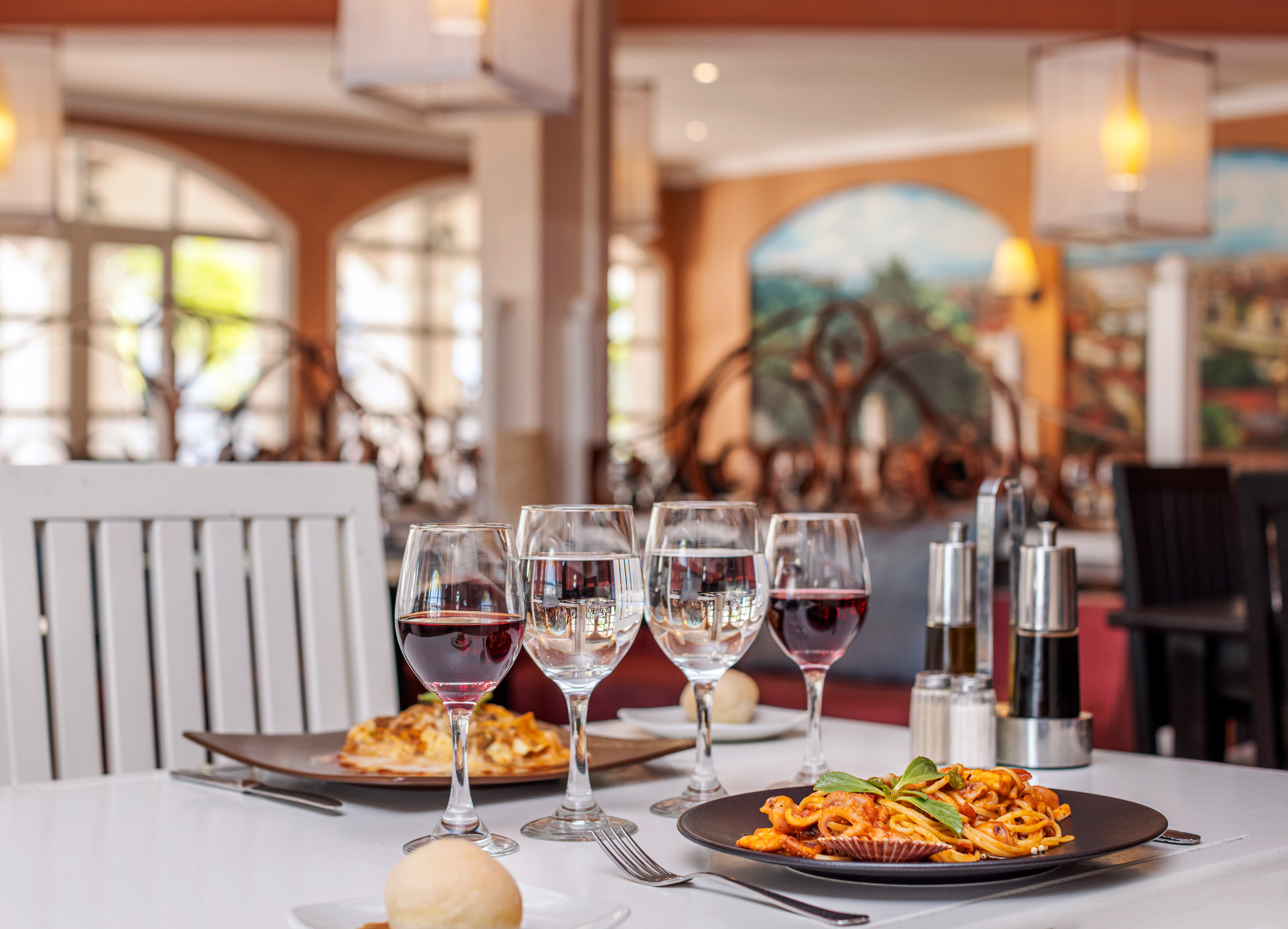 a table with plates of food and wine glasses
