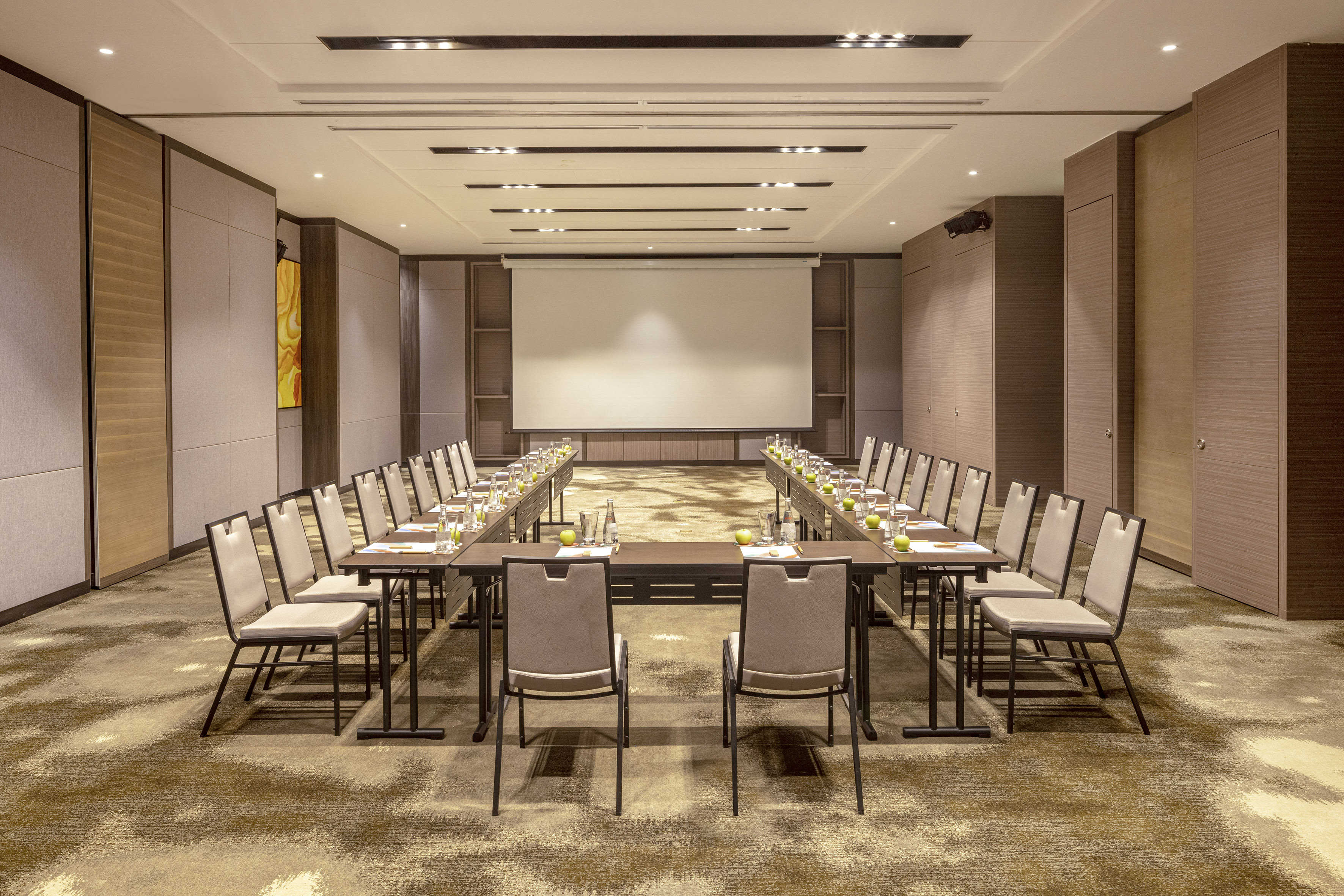 Hotel meeting room with U-shaped table setup, chairs, and projector screen. - Boardroom 1 - Meliá Vinpearl Thanh Hoa, Thanh Hoa