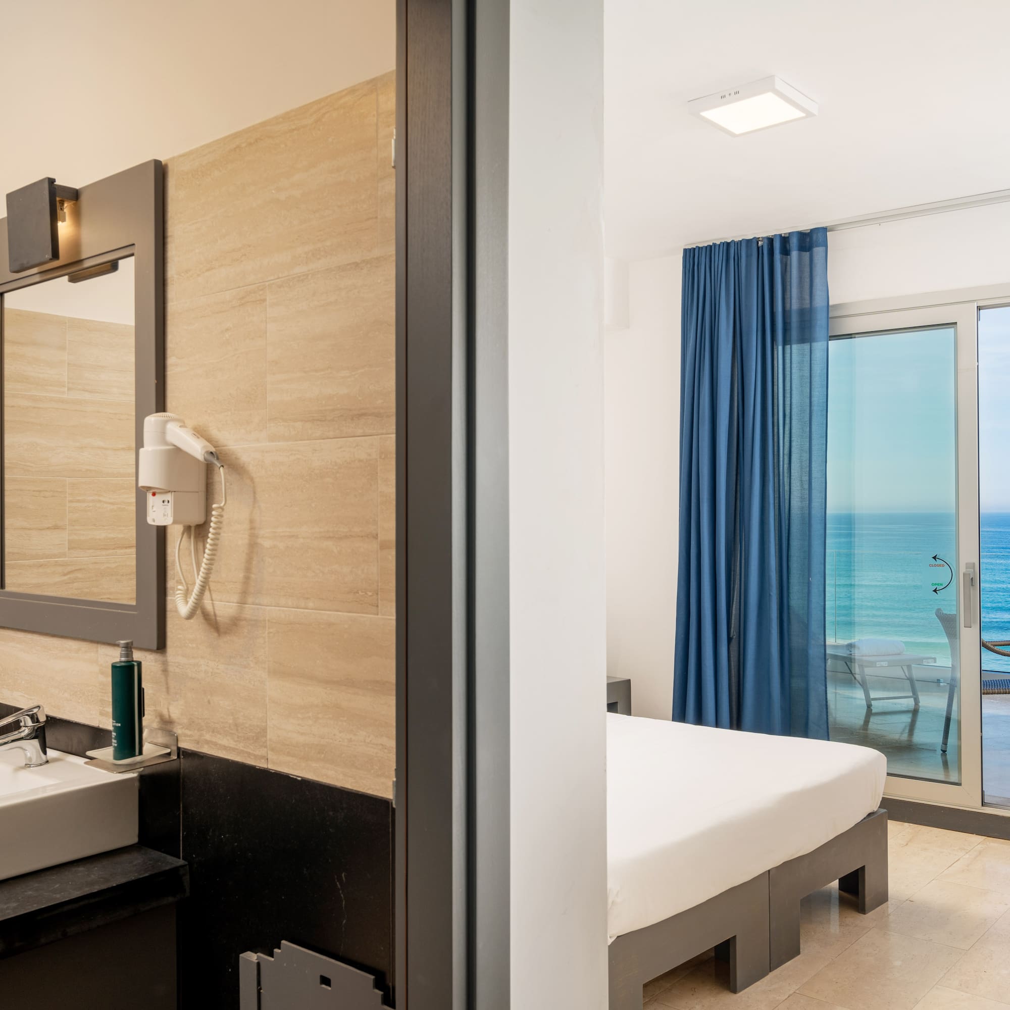 a bathroom with a large window and a bed and a mirror