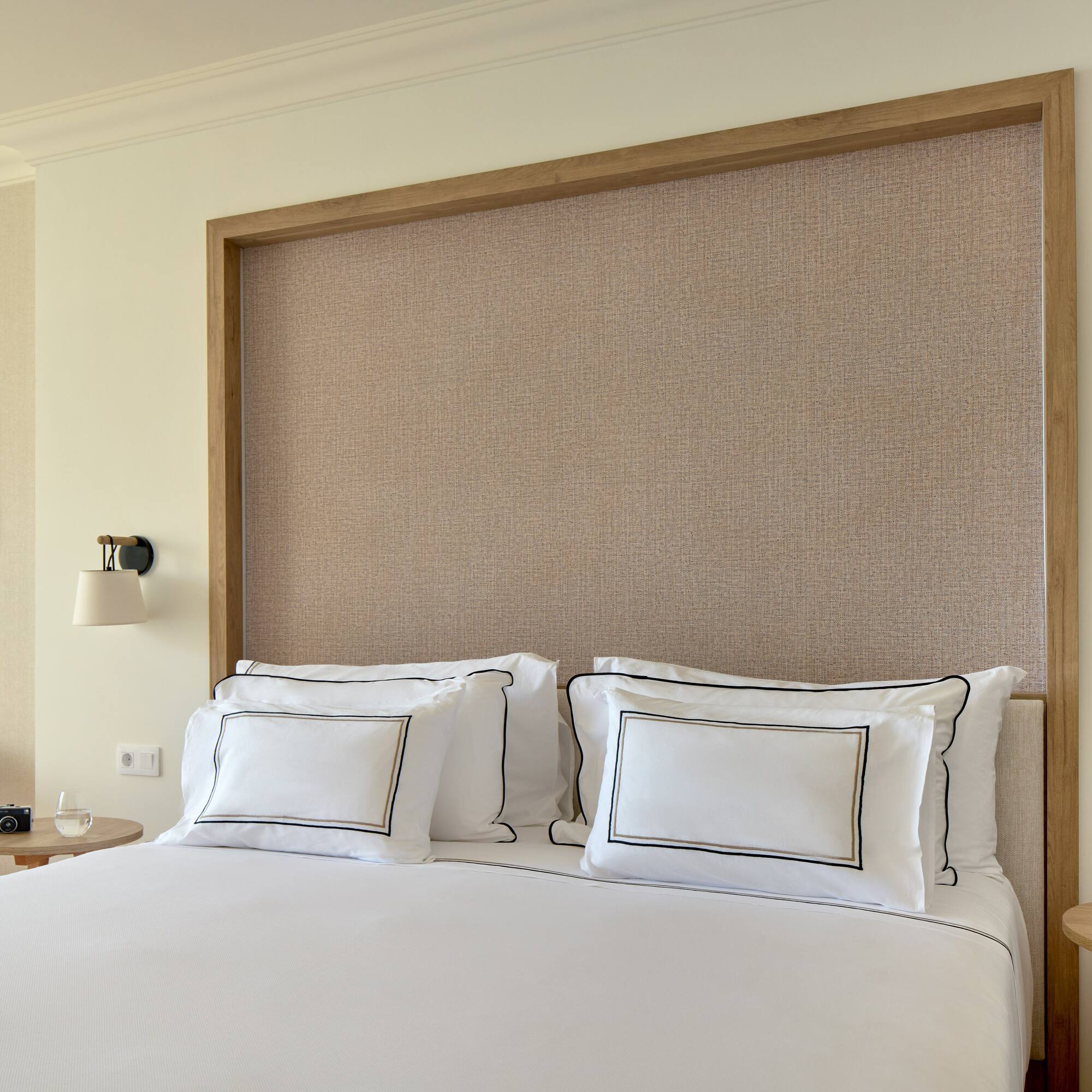 a bed with white sheets and pillows