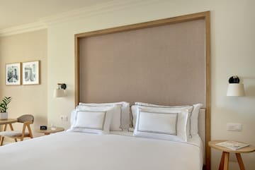 a bed with white sheets and pillows