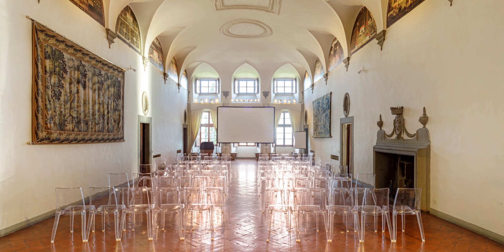 a room with many clear chairs and a screen