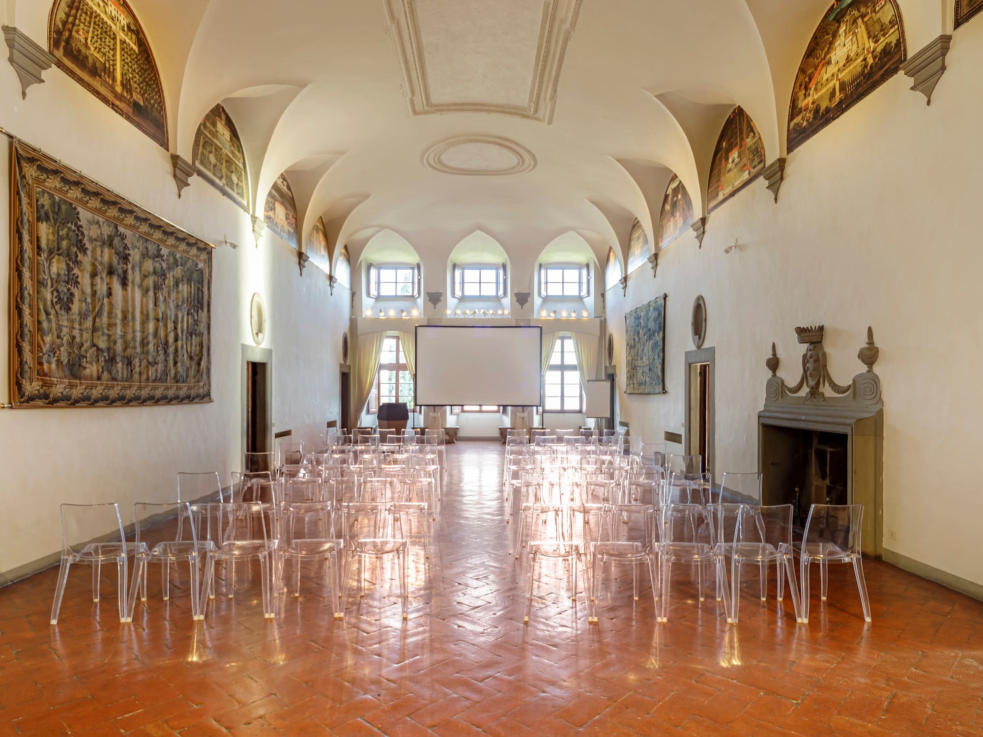 a room with many clear chairs and a screen