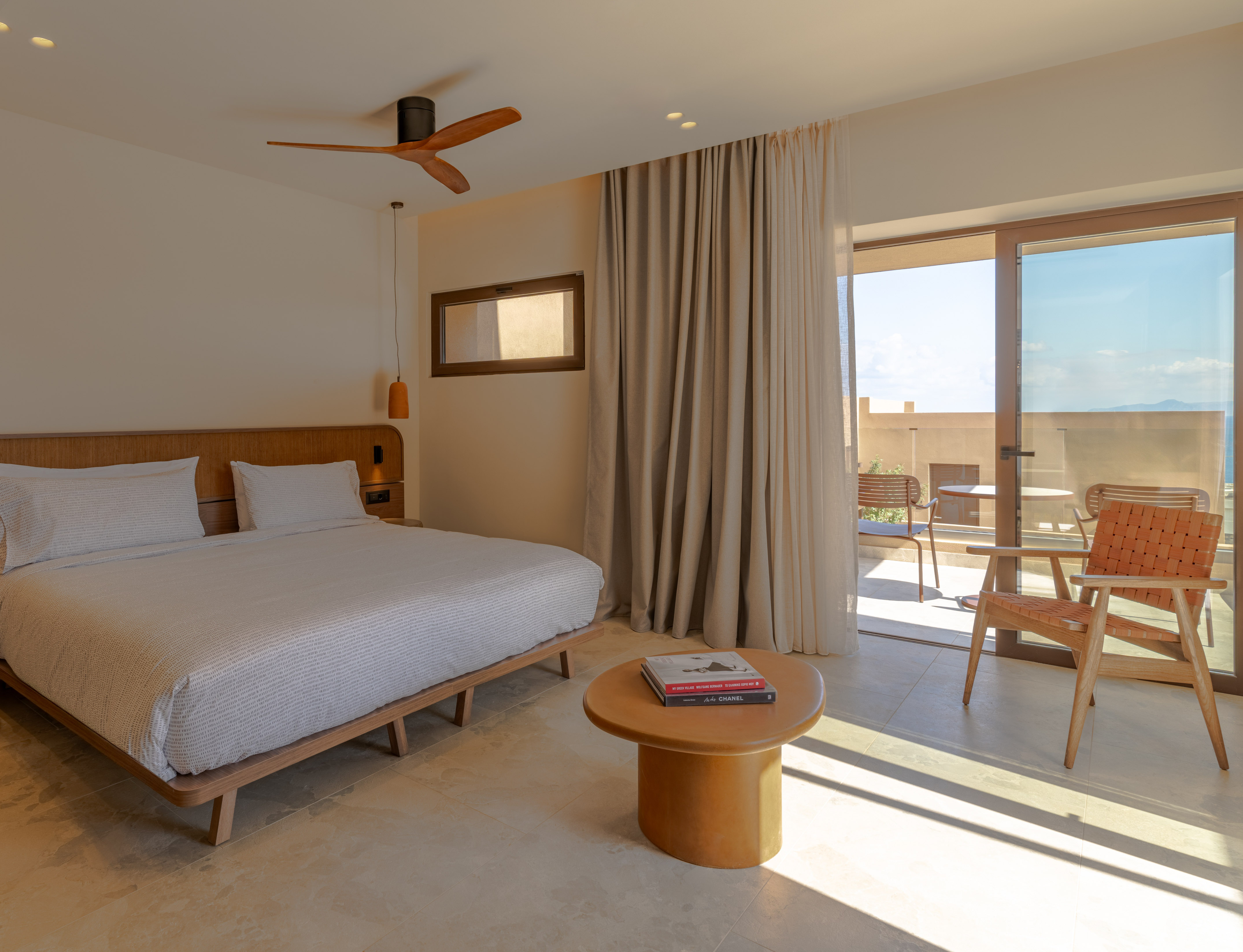 Modern hotel bedroom with king bed, wooden accents, and balcony.