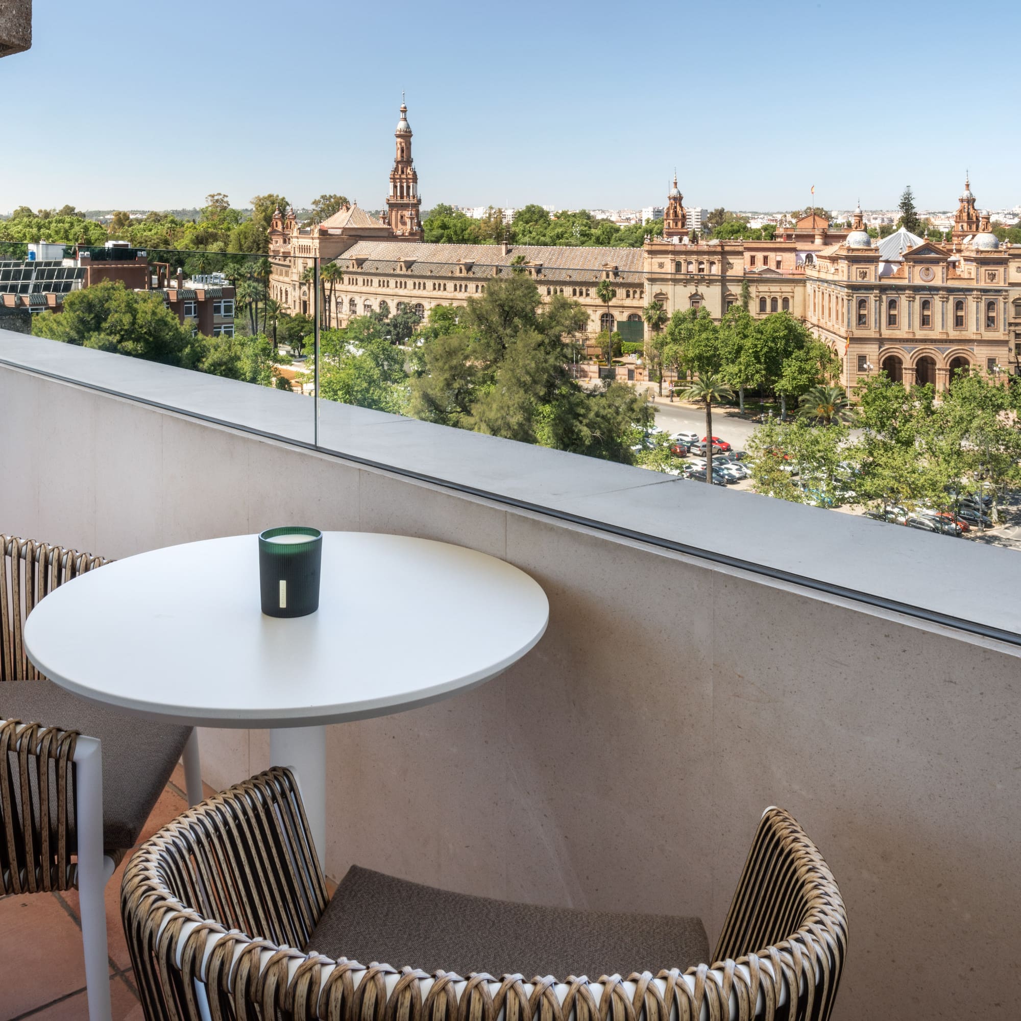 a table and chairs on a balcony overlooking a city