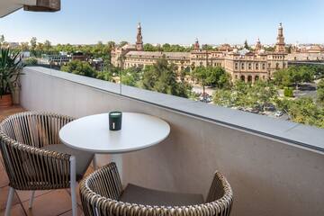 a table and chairs on a balcony overlooking a city