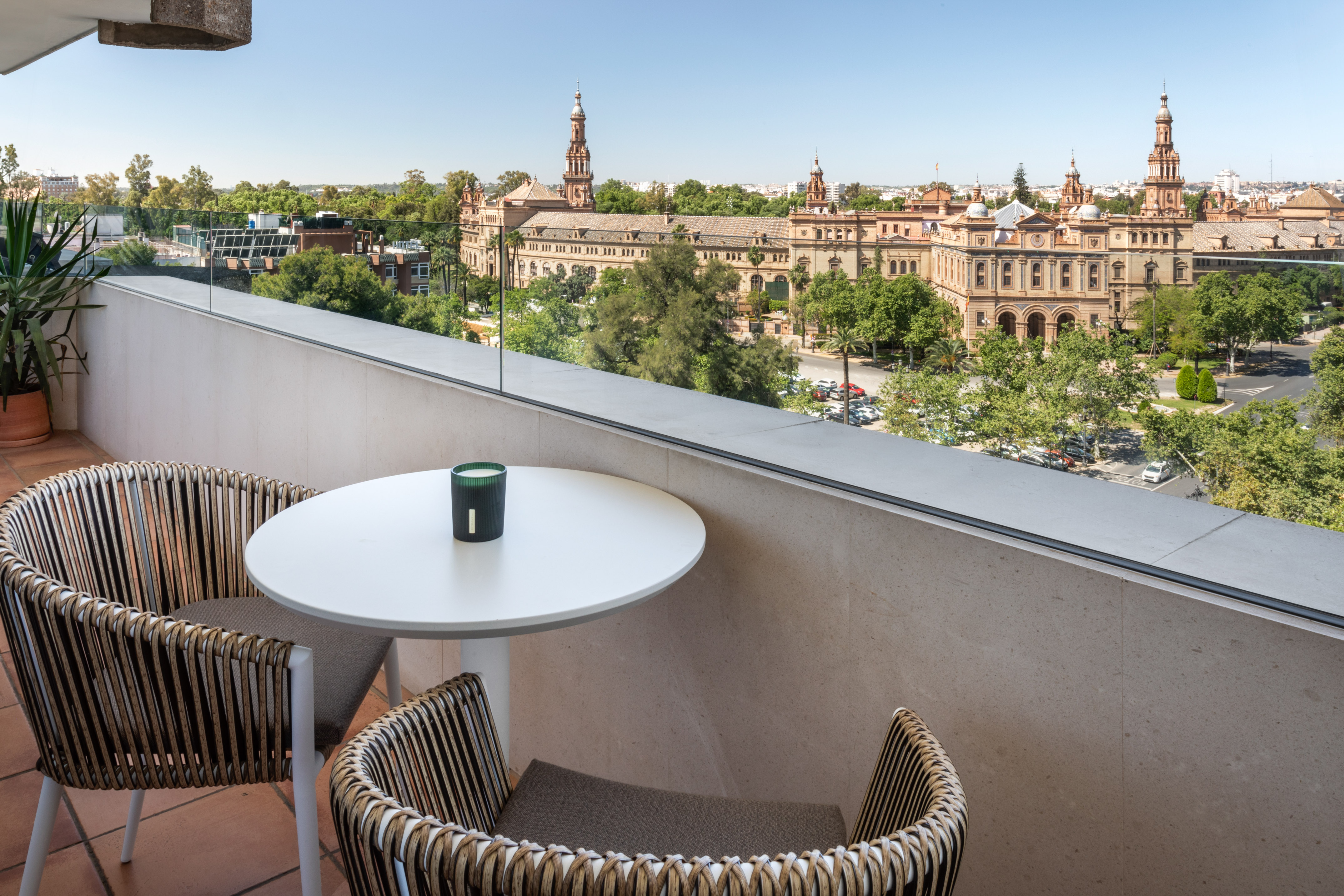 Balcony with outdoor seating overlooking Plaza de España, Seville.