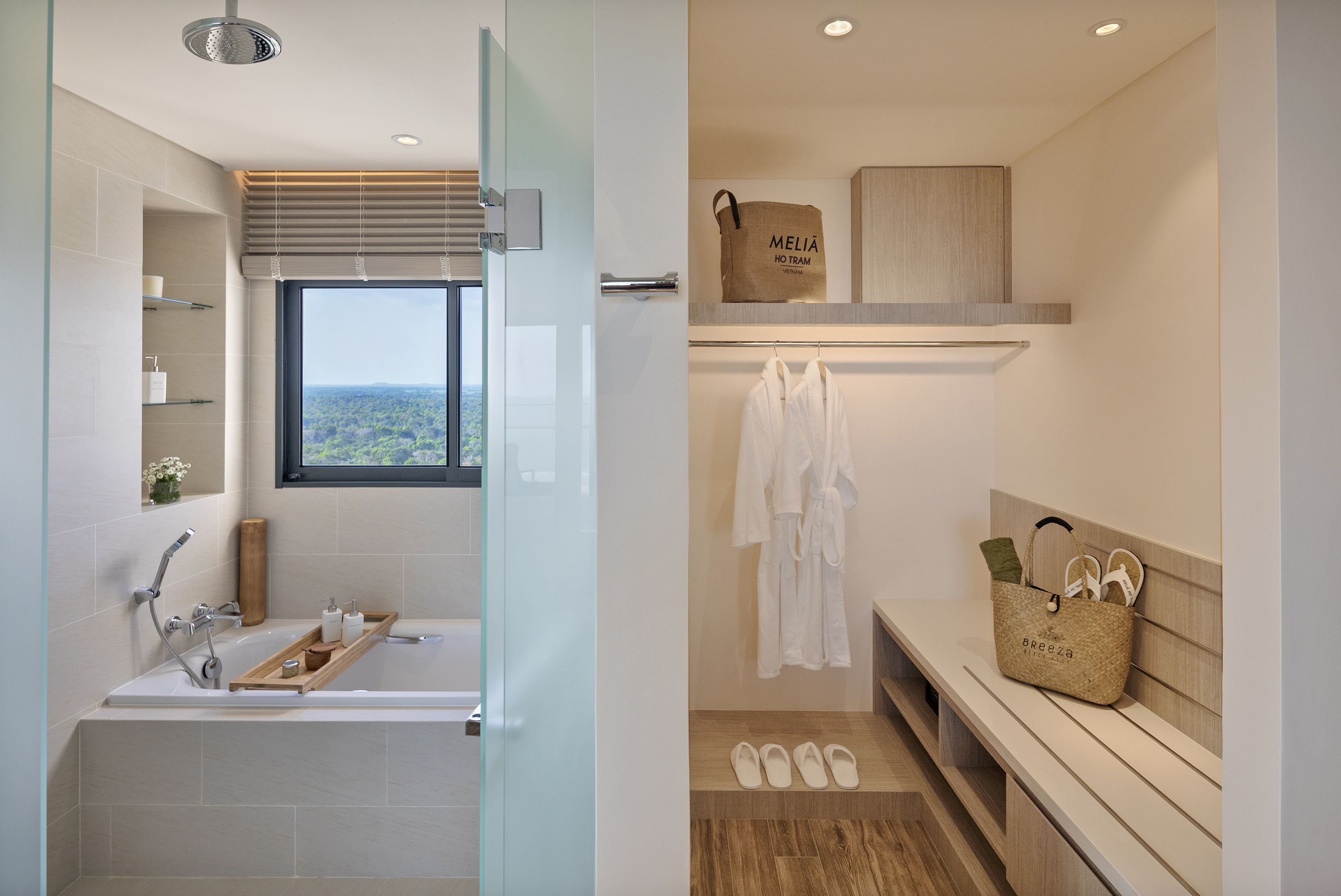 Luxurious Melia Ho Tram bathroom with bathtub, forest view, and open closet.