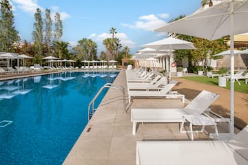 a pool with white chairs and umbrellas