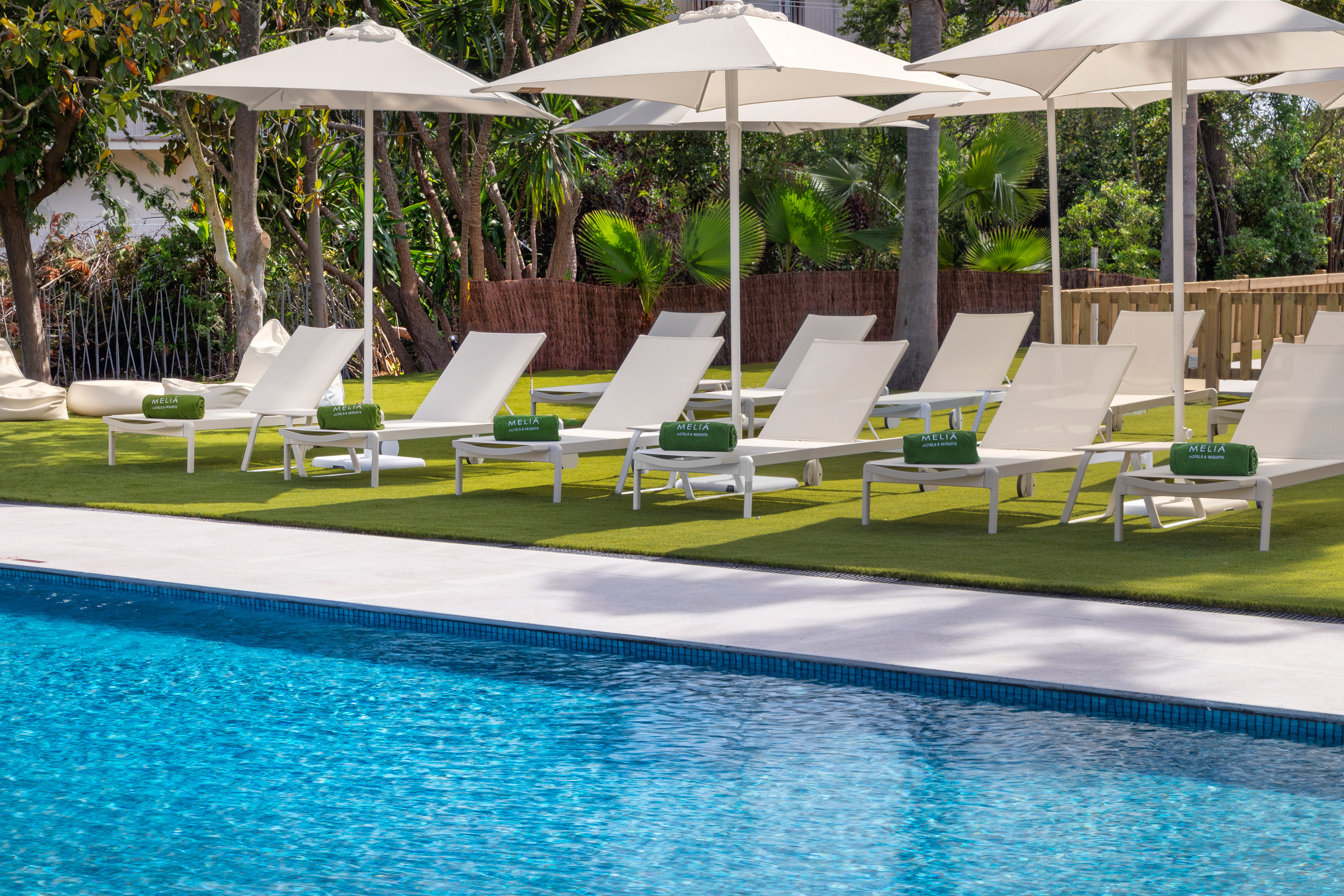 a pool with white chairs and umbrellas